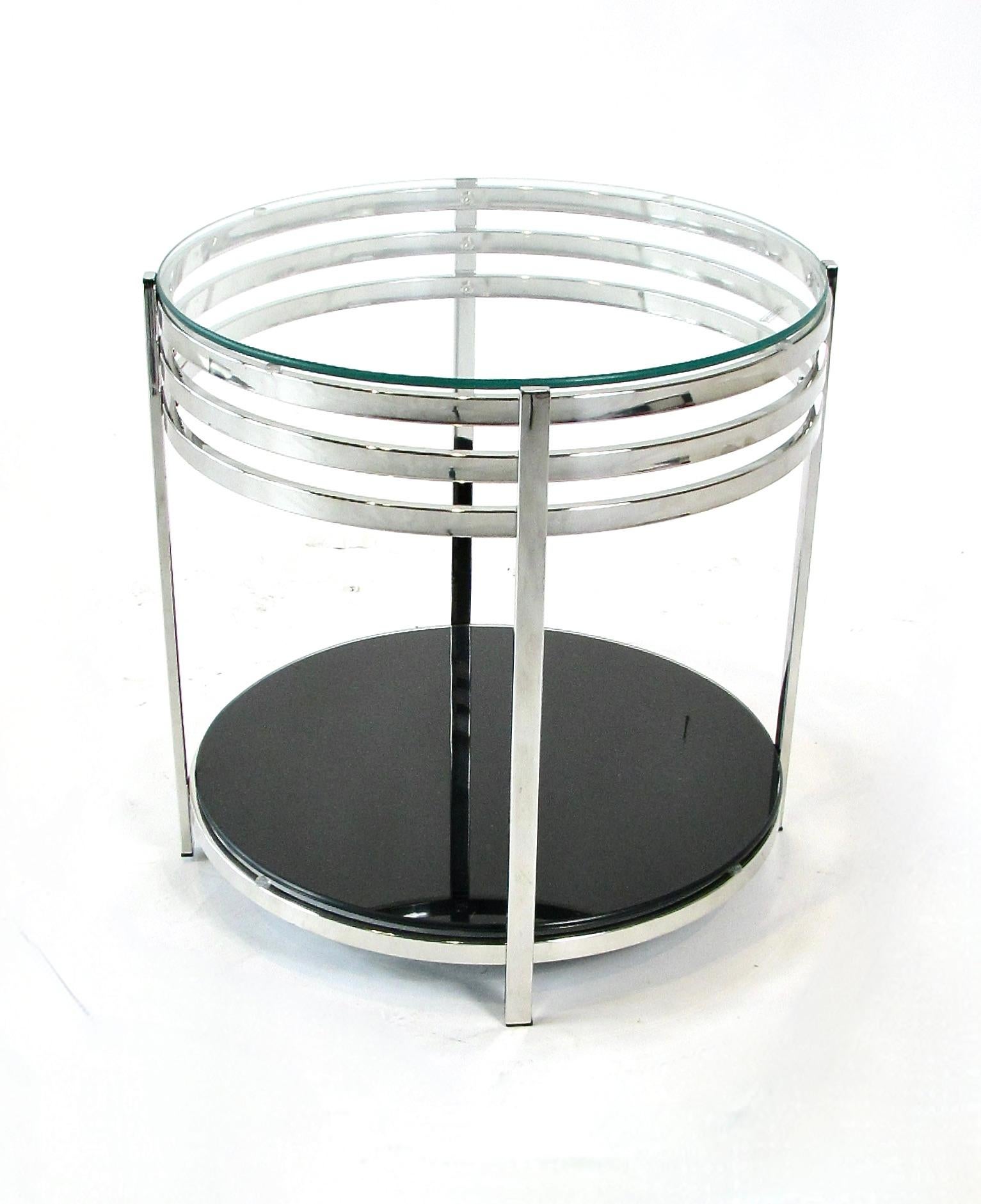 Riproduce l'aspetto dei mobili Deskey o Rohde dell'era delle macchine degli anni Trenta. Tavolo con struttura cromata e decorazione a fascia di velocità in stile classico Art Decor  supporta un piano in vetro trasparente e un piano inferiore in