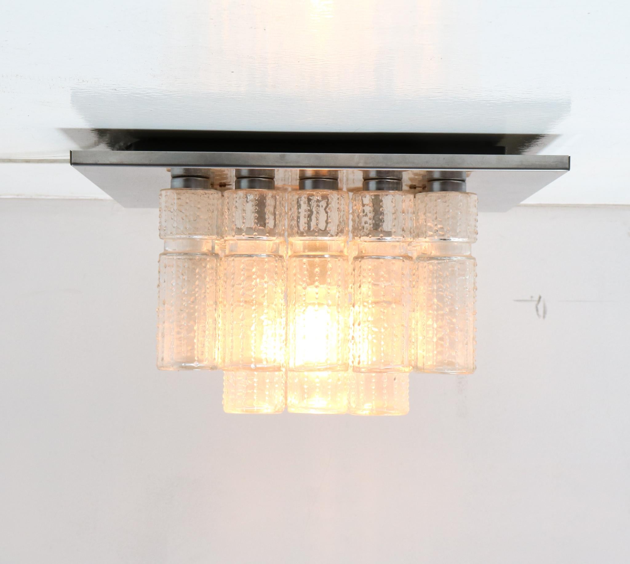 Magnificent and funky Mid-Century Modern flush mount ceiling light.
Design by Boris Tabacoff for Glashütte Limburg.
Striking German design from the 1970s.
Chrome frame with 24 original hand-blown textured hollow glass prisms.
Marked with