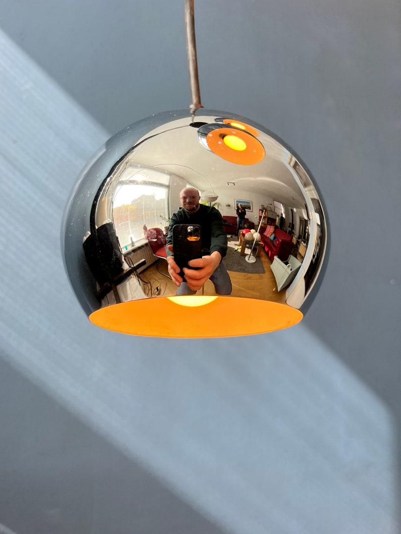 Very shiny mid century cascade pendant lamp with three chrome eyeball shades. The shades can easily be adjusted in height seperately. The lamp requires three E27/26 lightbulbs.

Additional information:
Materials: Metal
Period: 1970s
Dimensions:ø