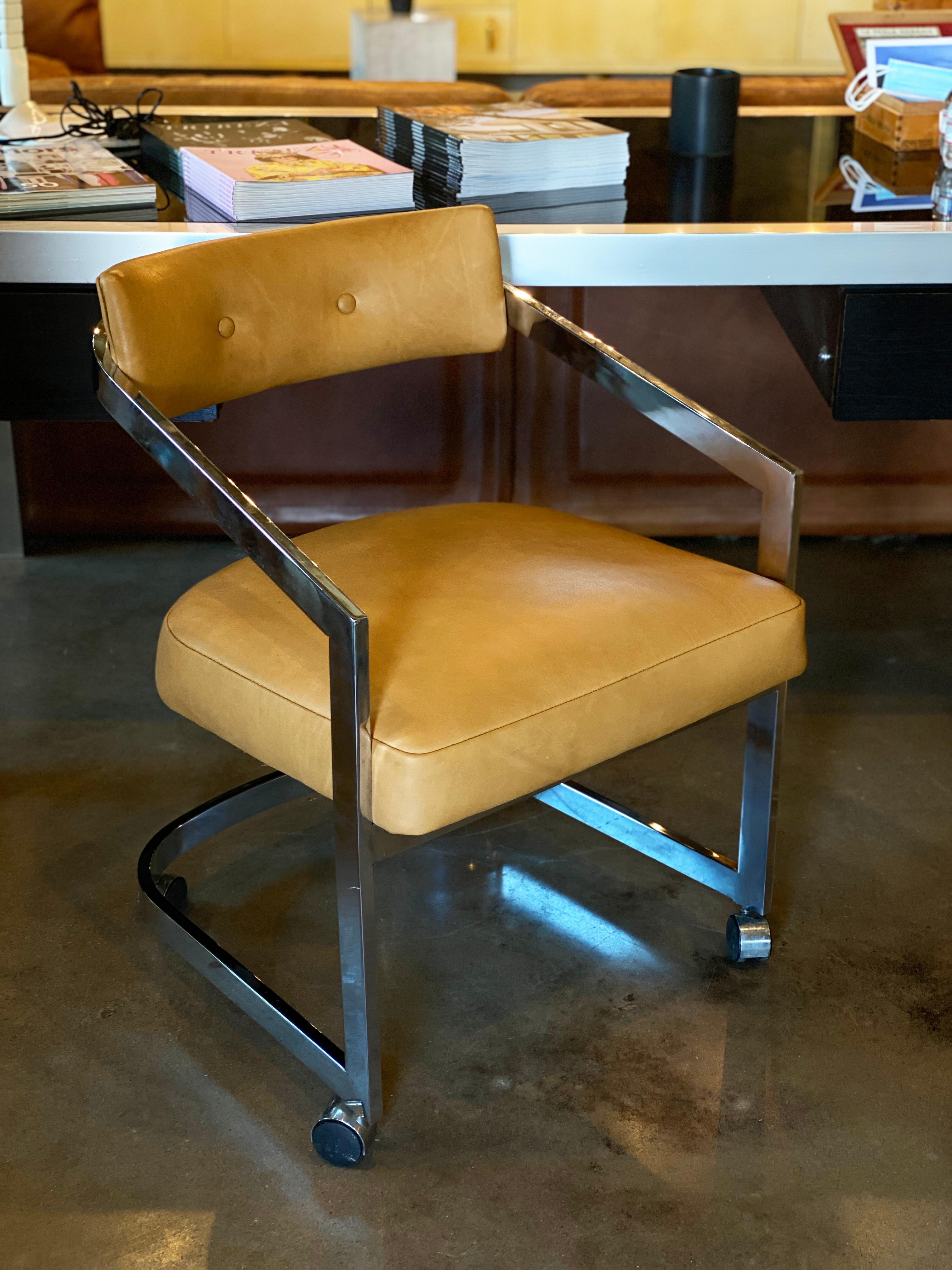 Chrome cantilevered dining chairs on casters by  Design Institute of America, labeled, 1982. New custom upholstery in rich aniline-dyed leather (light brown to a camel in color). Seat height 18.5 inches.

Four additional chairs are available in the