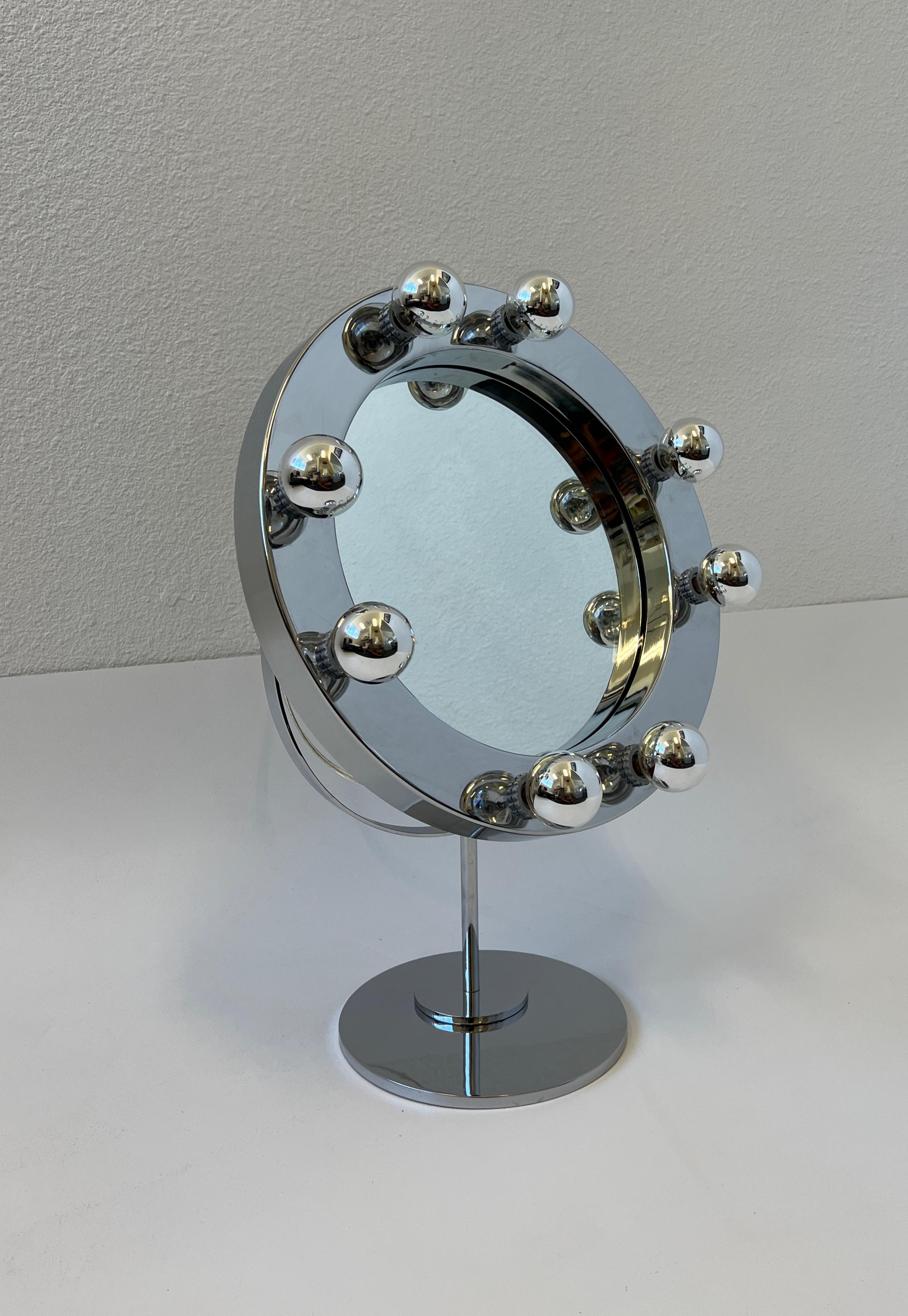 Glamorous O Vanity mirror design by American renowned designer Charles Hollis Jones in the 1960’s. The mirror is adjustable, newly rewired with a built in full range dimmer on the back. It takes eight 25w dipped chrome candelabra lightbulb. 
In