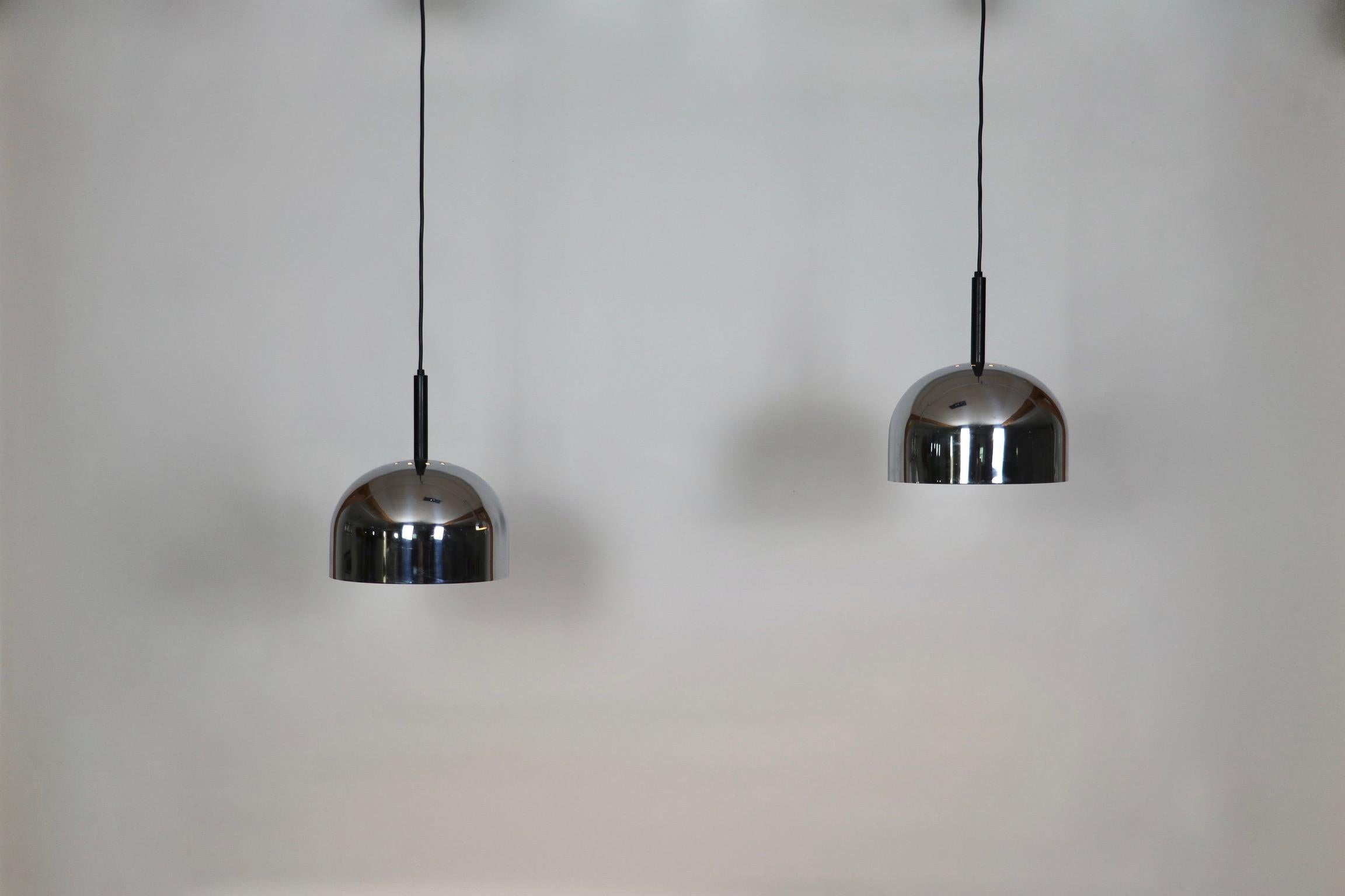 Nice pair of chromed metal pendant lamps, designed by Gal Aulenti and Livio Castiglioni for Stilnovo, Italy 1960s.
A timeless masterpiece of design collaboration between the renowned talents of Gae Aulenti and Livio Castiglioni, brought to life by