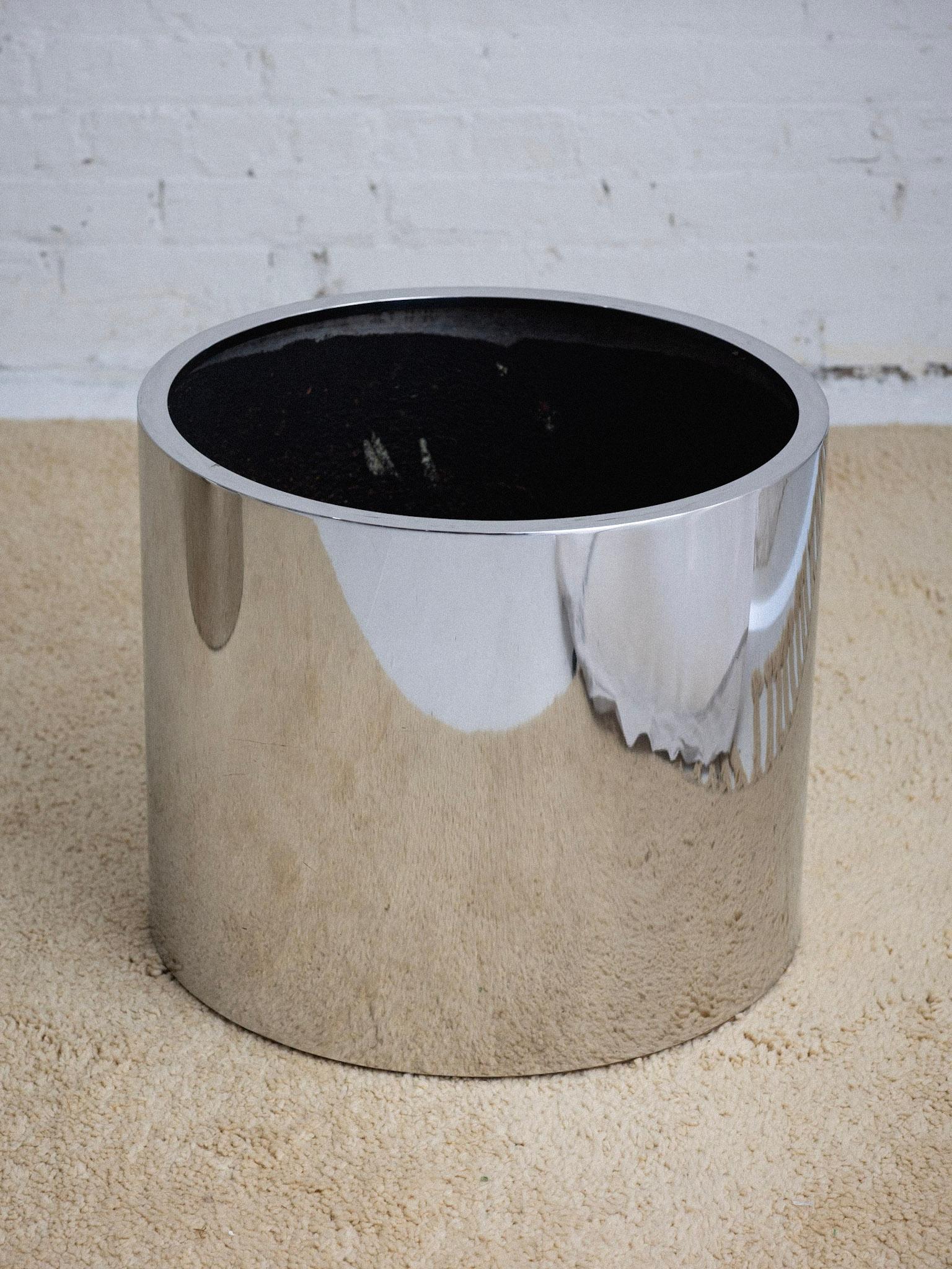 A large polished aluminum drum planter attributed to Paul Mayen for Habitat. Lustrous chrome finish. Coated interior and inner plywood base to protect metal from rusting. Pair available, sold separately.