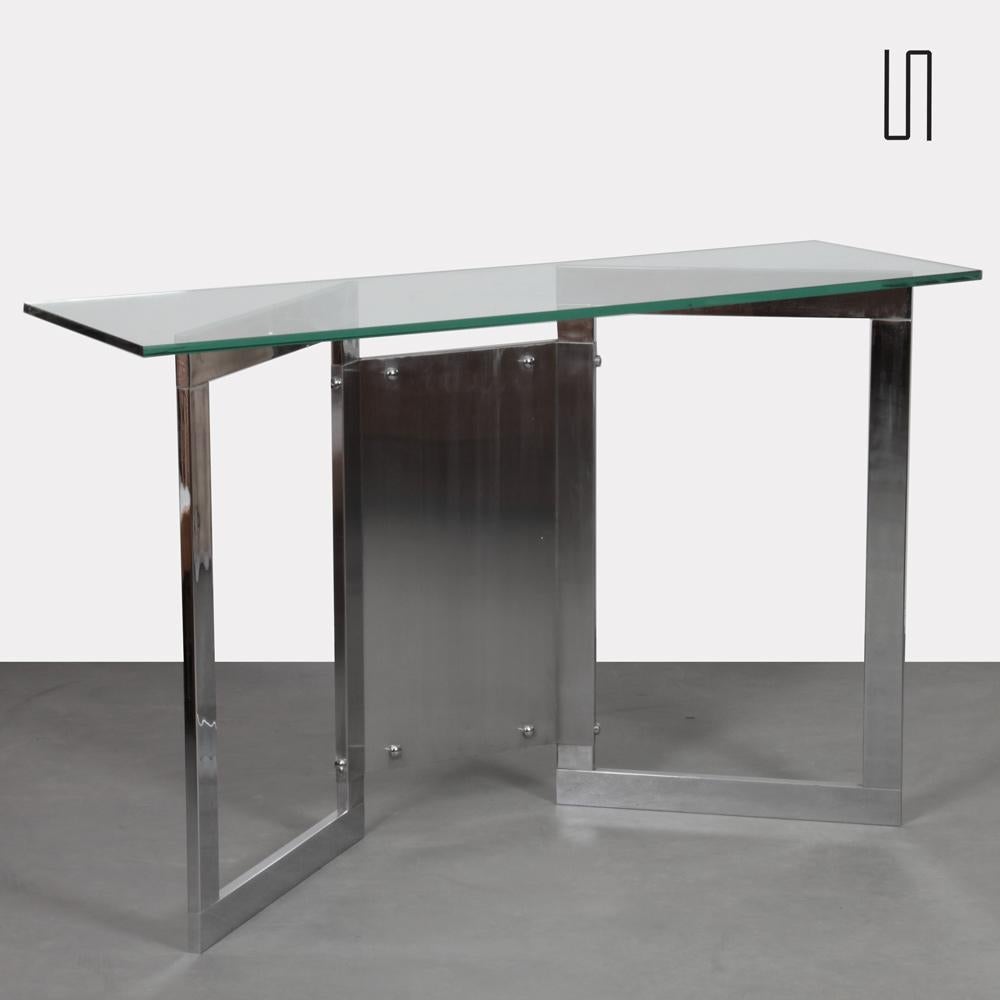 This chrome-plated metal console dates from the 1970s. The top is in glass. It is in good original condition.