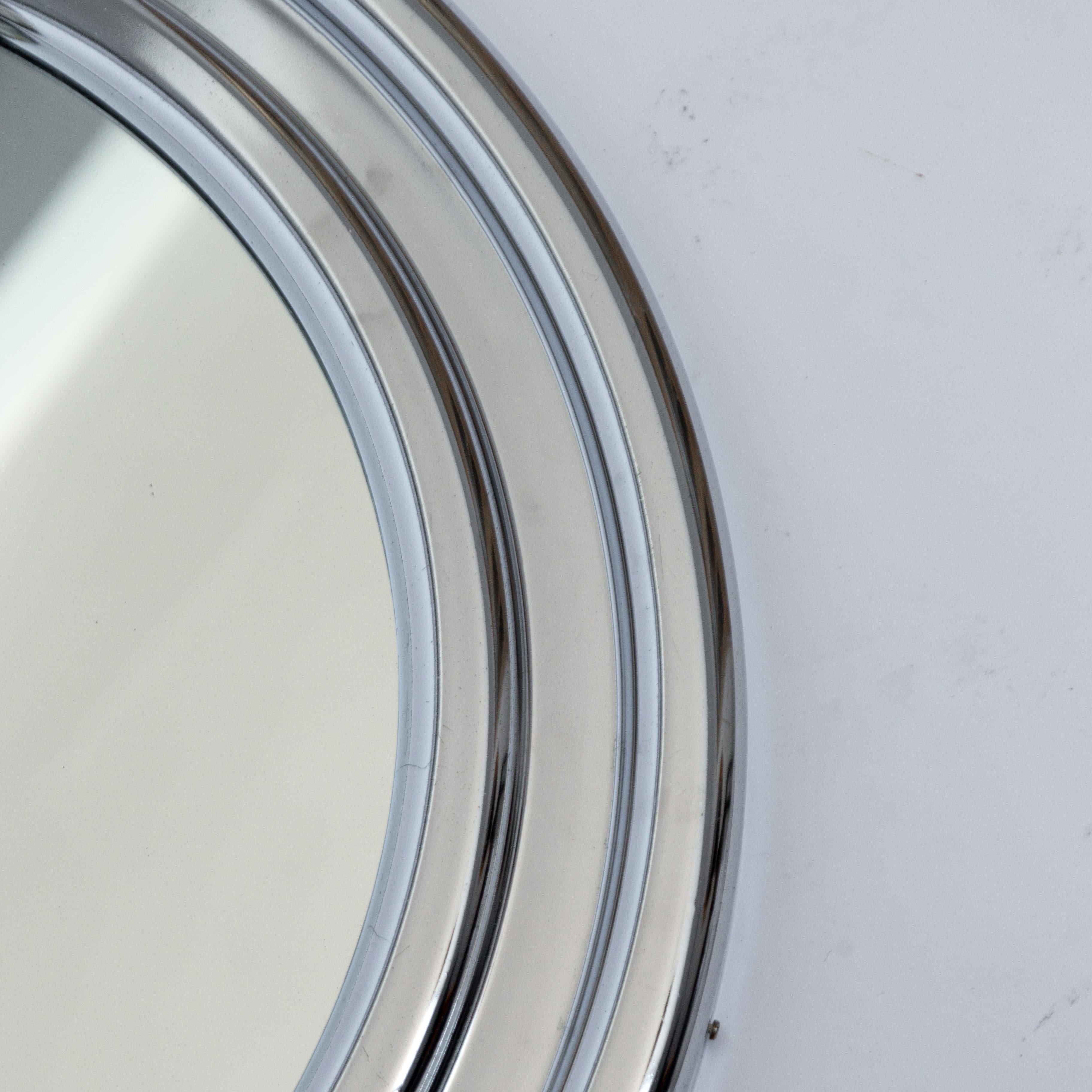 Large round space aged metal chrome-plated frame and glass wall mirror from the 1970s. Measures: Diameter 60 cm.