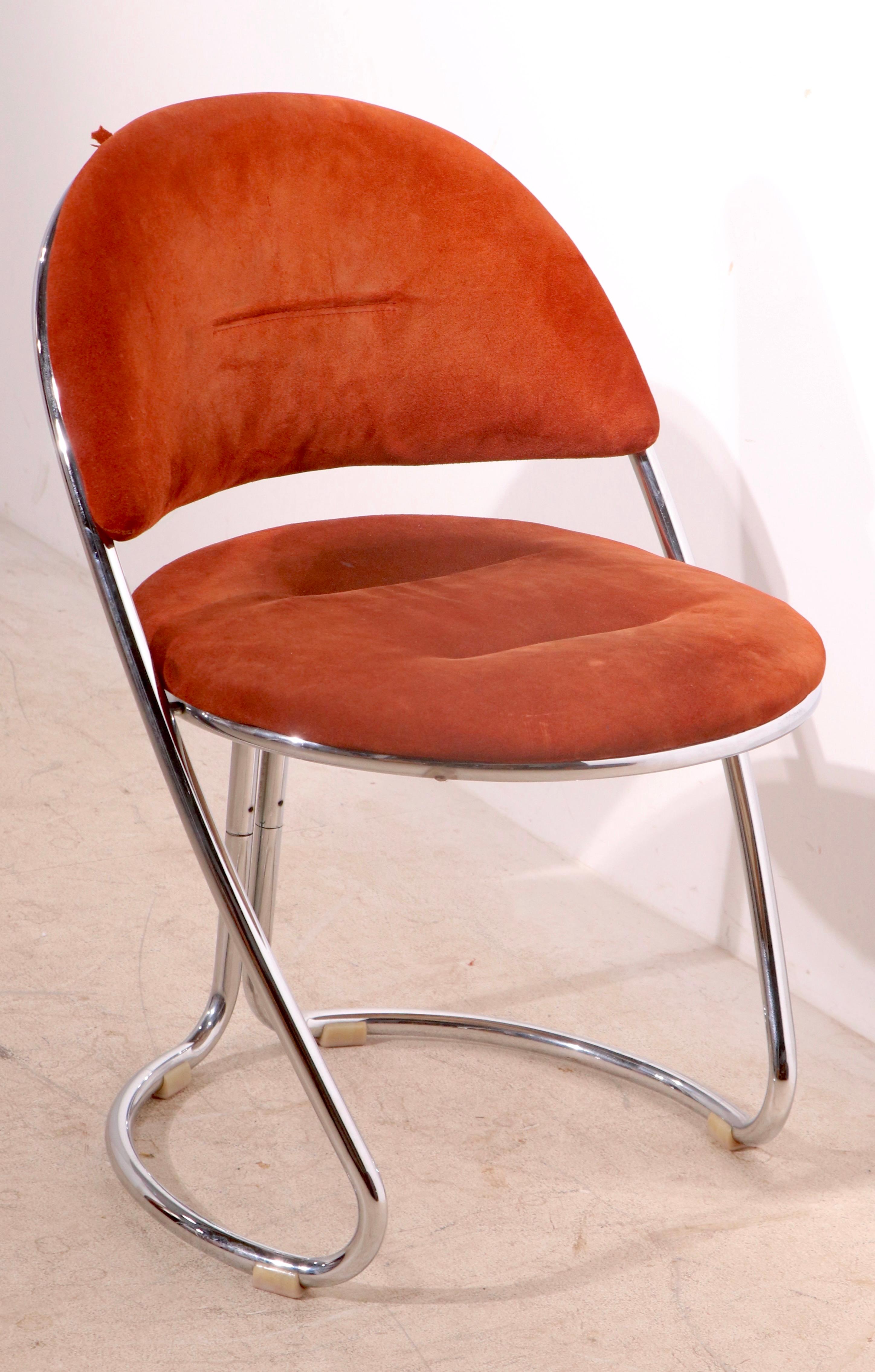 Dramatic post modern side, or dining chair, made in Italy, circa 1970’s, attributed to Giotto Stoppino. The chair features a bright tubular chrome frame, with an ultra suede upholstered back, and seat ( upholstery as is ). This example is