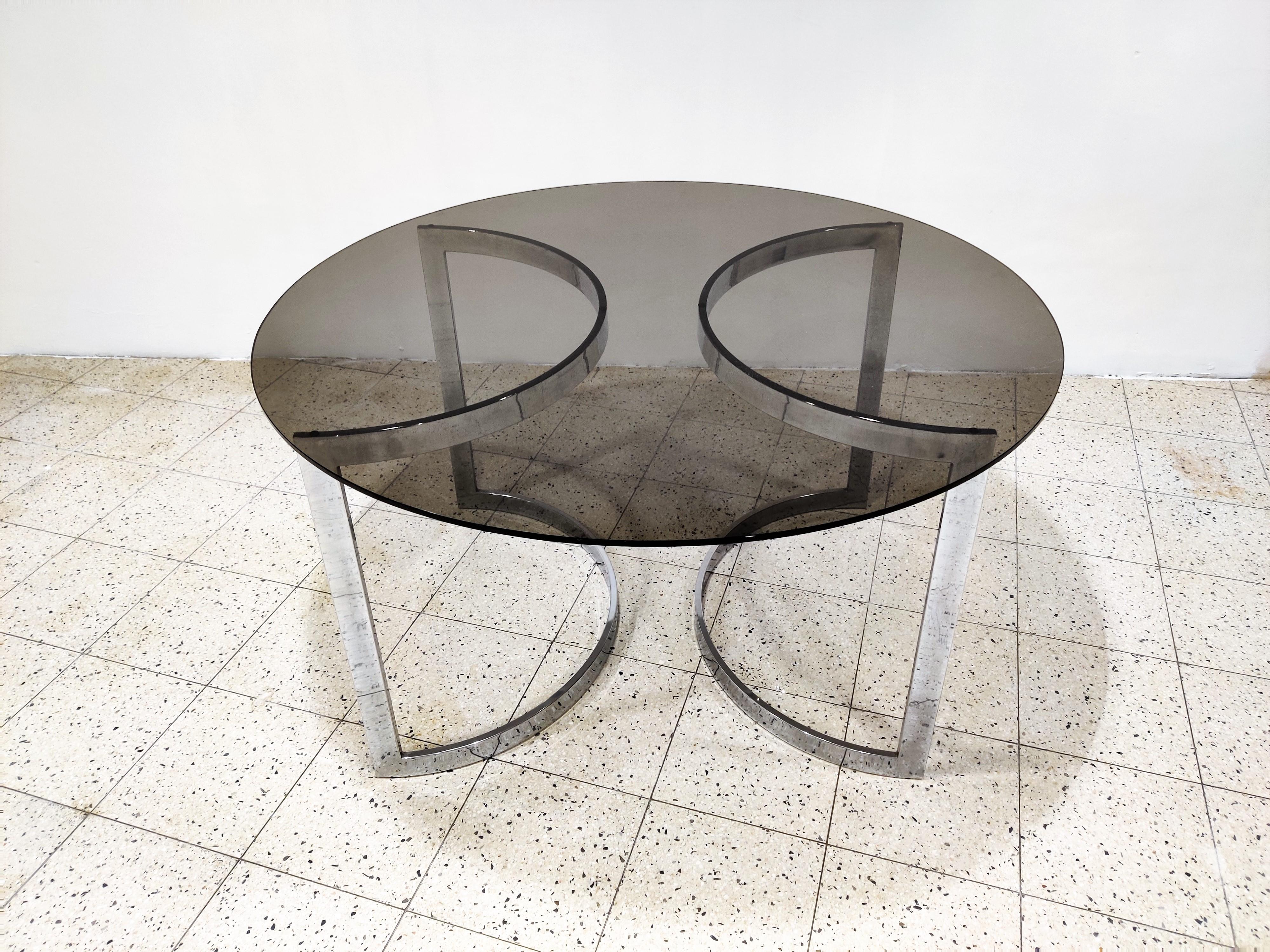 Beautiful Minimalist chromed steel dining table with a round smoked glass top.

The bases can be placed in various ways.

Good condition.

Charming, timeless piece for in the kitchen or dining room.

1970s - France

Measures: Height