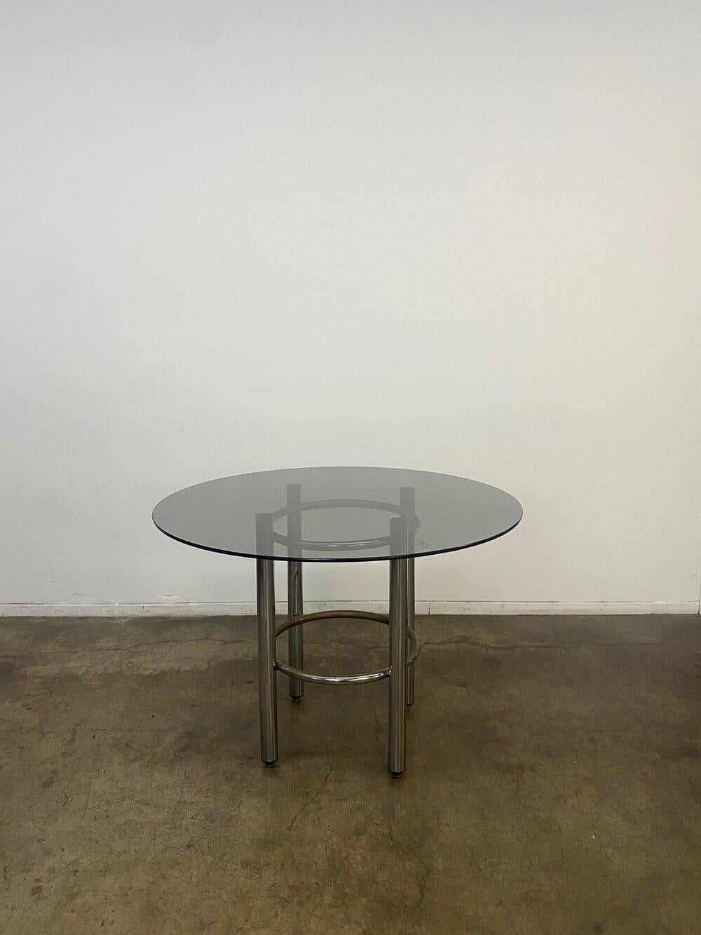 Round Chrome and Smoked glass dining table. Item is in vintage condition and has patina. 
