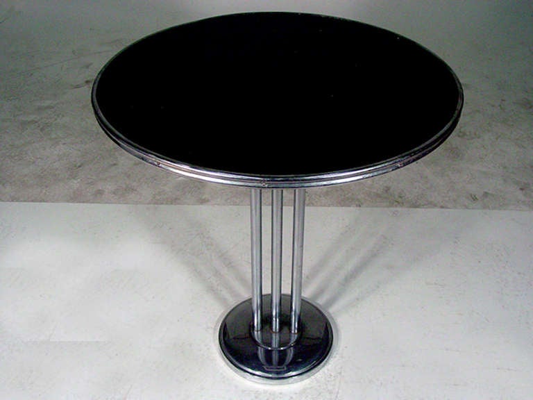 Streamlined side table with a chrome-tubular steel base and decorative chrome trim. It has a versatile size and could be used as a center table, lamp table, end or side table.