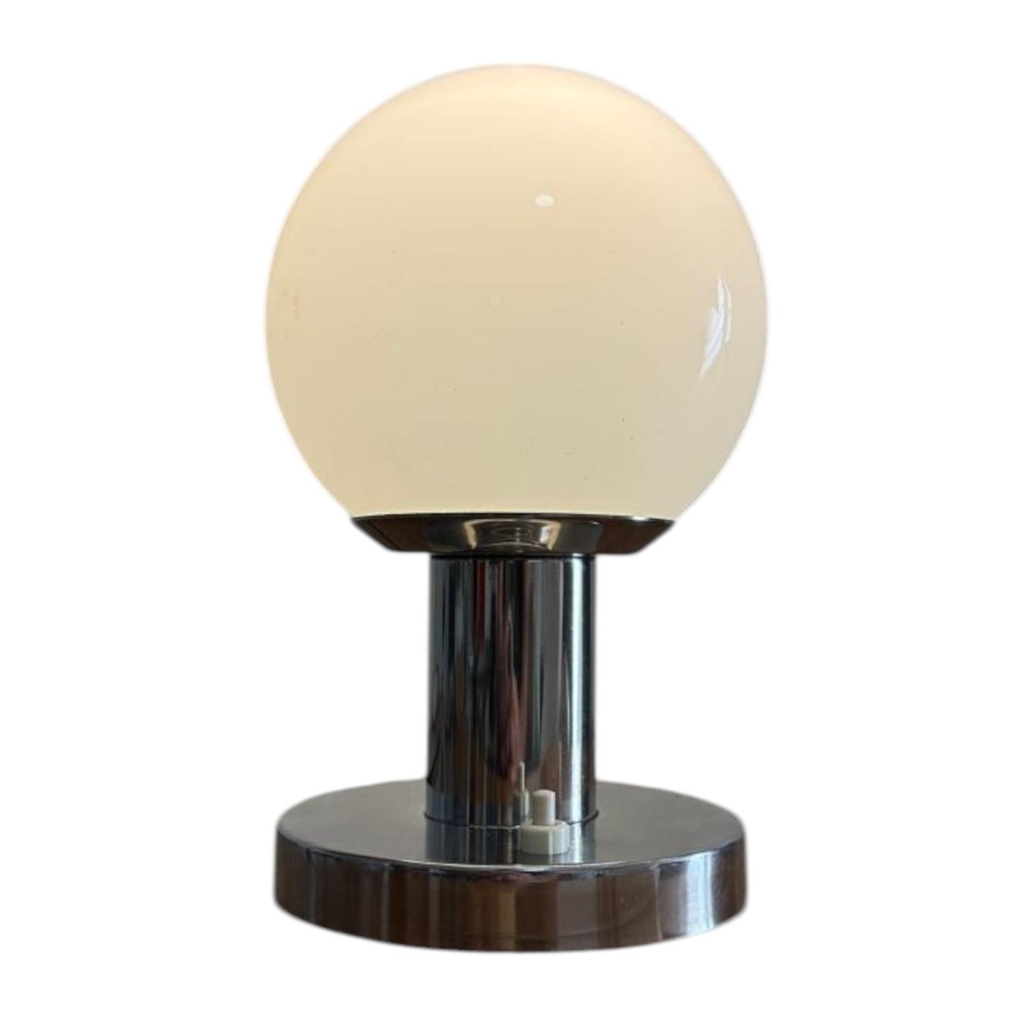 Table lamp with a minimalist chrome frame and glass sphere. Beautiful space-age/postmodern design. Renewed wiring, also cleaned, inspected, and tested. In good vintage condition, with minor signs of wear on the chrome frame.