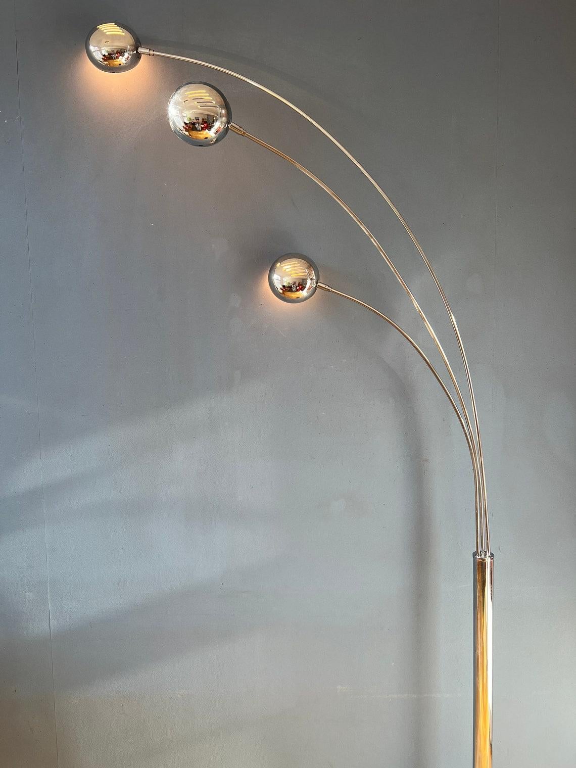 Chrome 'three finger' arc floor lamp made in the 80s. The arcs are flexible and can be aligned or positioned in opposite direction. Also the shades can be adjusted. The lamp requires three E27/26 lightbulbs (one for each shade) and currently has an