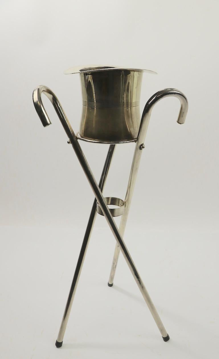 Stylish Ice bucket, Champagne stand having a chrome top hat bucket on three intersecting cane form legs. Overall very good condition, showing some wear to plating, normal and consistent with age. Top hat without Stand 7 height x 9.25 diameter inch.