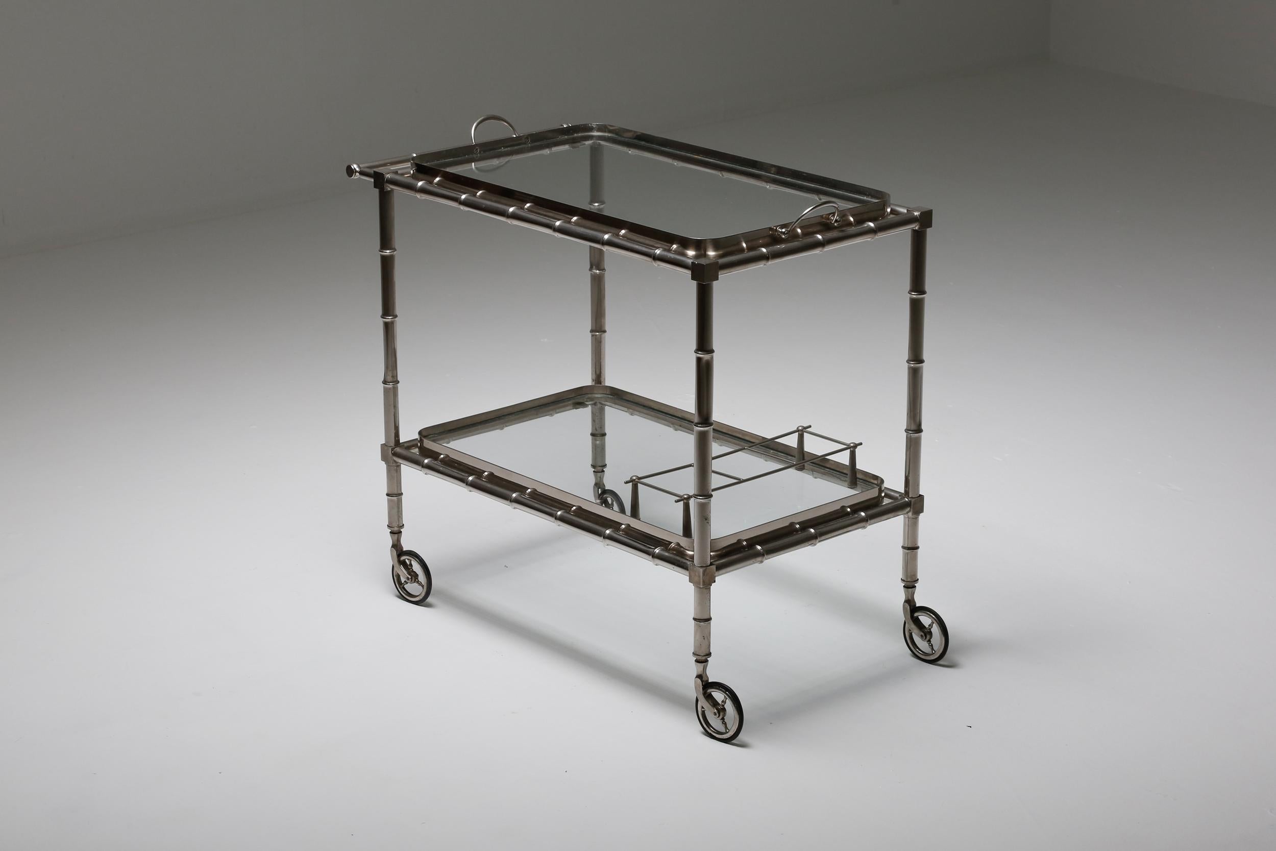 Elegant chrome trolley on wheels exudes in regency design, making it a sophisticated addition to any space. Featuring two glass trays, it serves as an ideal solution for both serving and storing drinks, as well as other items. Crafted in France