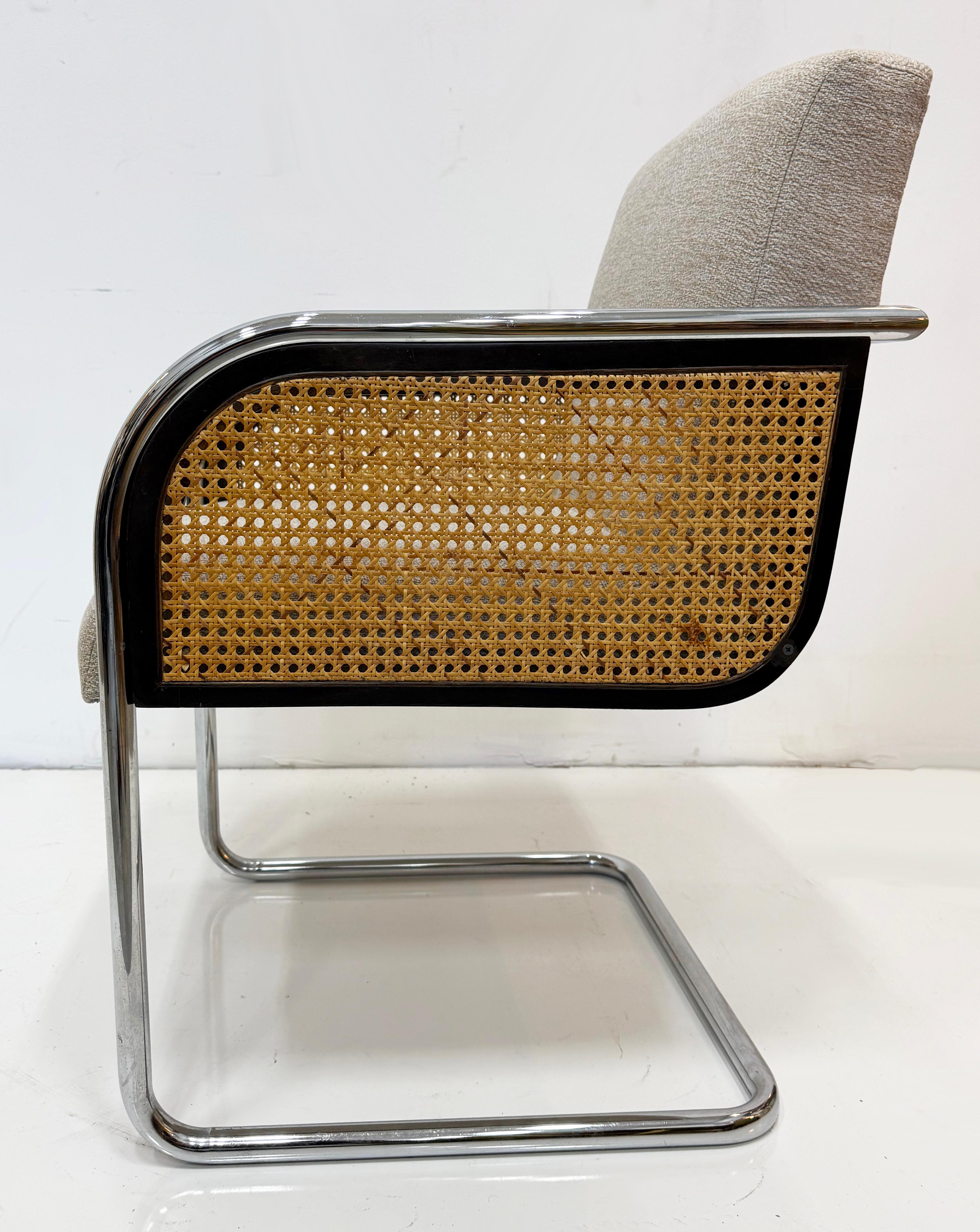 Chrome Upholstered Cane Cantilever Armchairs, Thonet Attributed, Pair

Offered for sale is a pair of vintage cantilever chrome and cane Thonet armchairs. The seats and backs are newly upholstered.  The sides of the chairs are caned below the arms