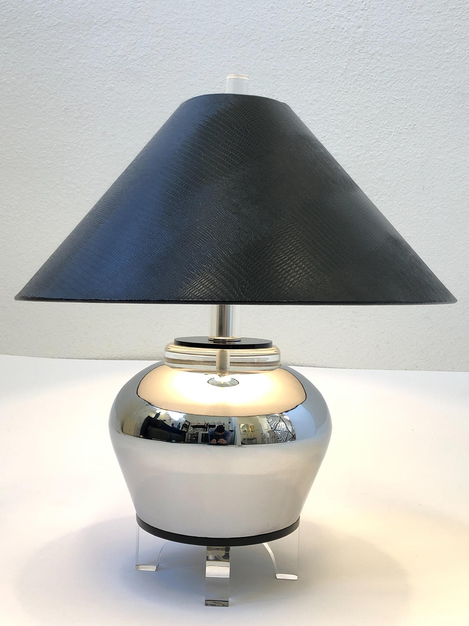 1980s polish chrome urn shape table lamp with clear and black Lucite details.
Original black faux lizard embossed lamp shade.
Overall dimensions: 21” high 19” diameter with shade.