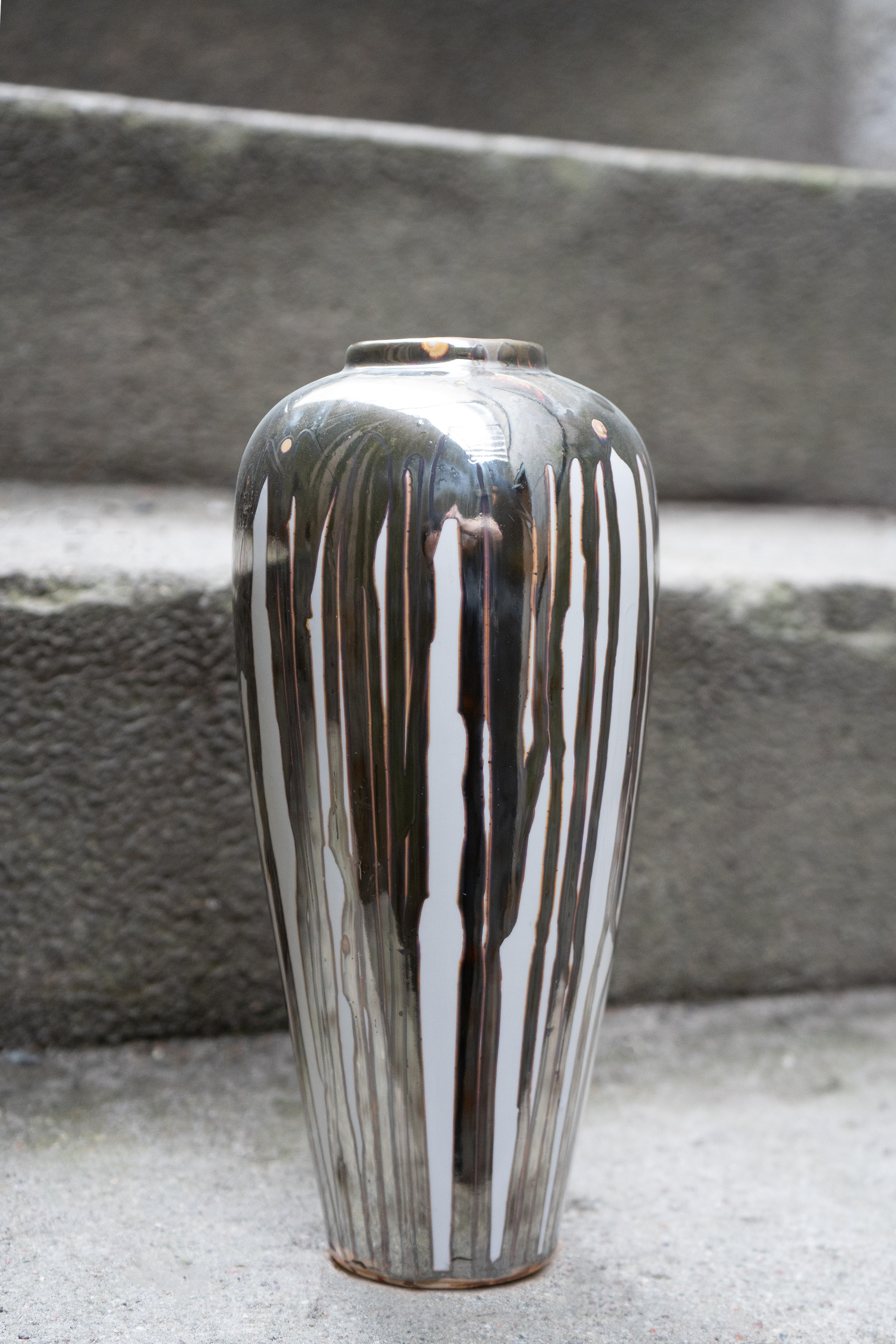 Vaso cromato 0001 di John Nordenstein
Un pezzo unico.
Dimensioni: D. 10 x L. 10 x H. 26 cm.
Materiali: Ceramica, vernice cromata e primer epossidico.

L'artista autodidatta John Nordenstein è cresciuto e lavora a Stoccolma e attualmente presenta la