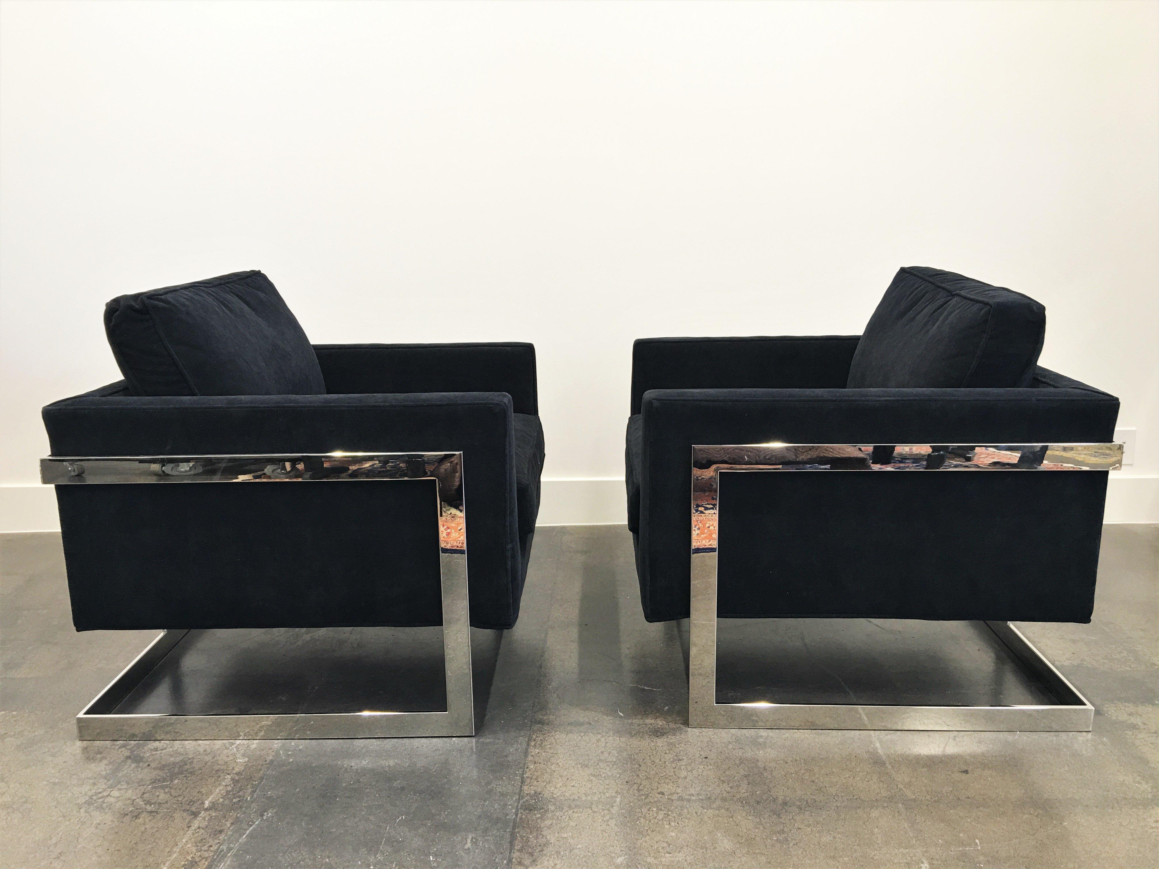 Pair of architectural club/lounge chairs by Milo Baughman for Thayer Coggin American, circa 1970. Rectilinear polished T-back steel frame supports an upholstered cube seat. These are the larger of the two that were made by Milo, hence wider and