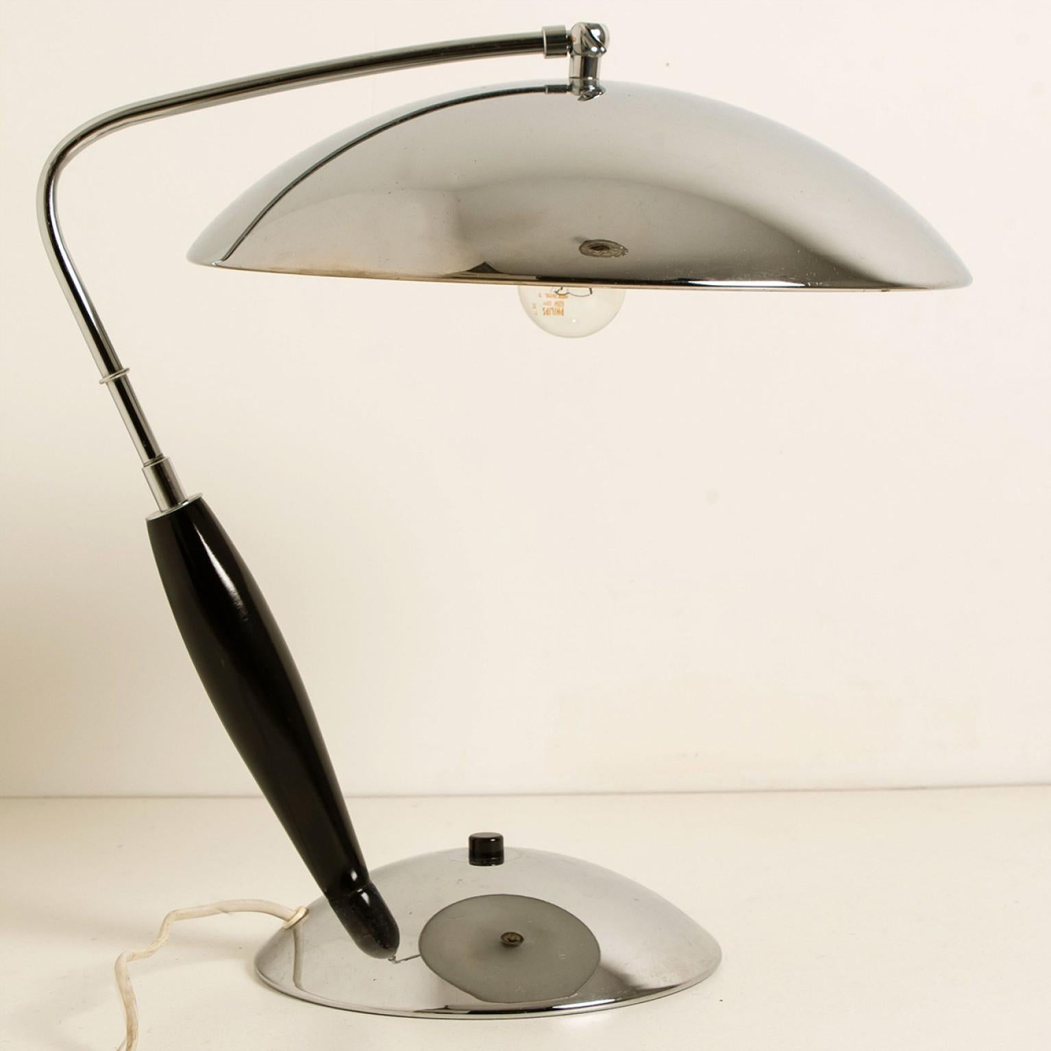 Vintage chrome table lamp with wooden detail, designed and manufactured in the 1970s.
It is possible to adjust the shade to your preference. With on/off button.

The stylish elegance of this lamp suits many interiors, from Midcentury to Danish