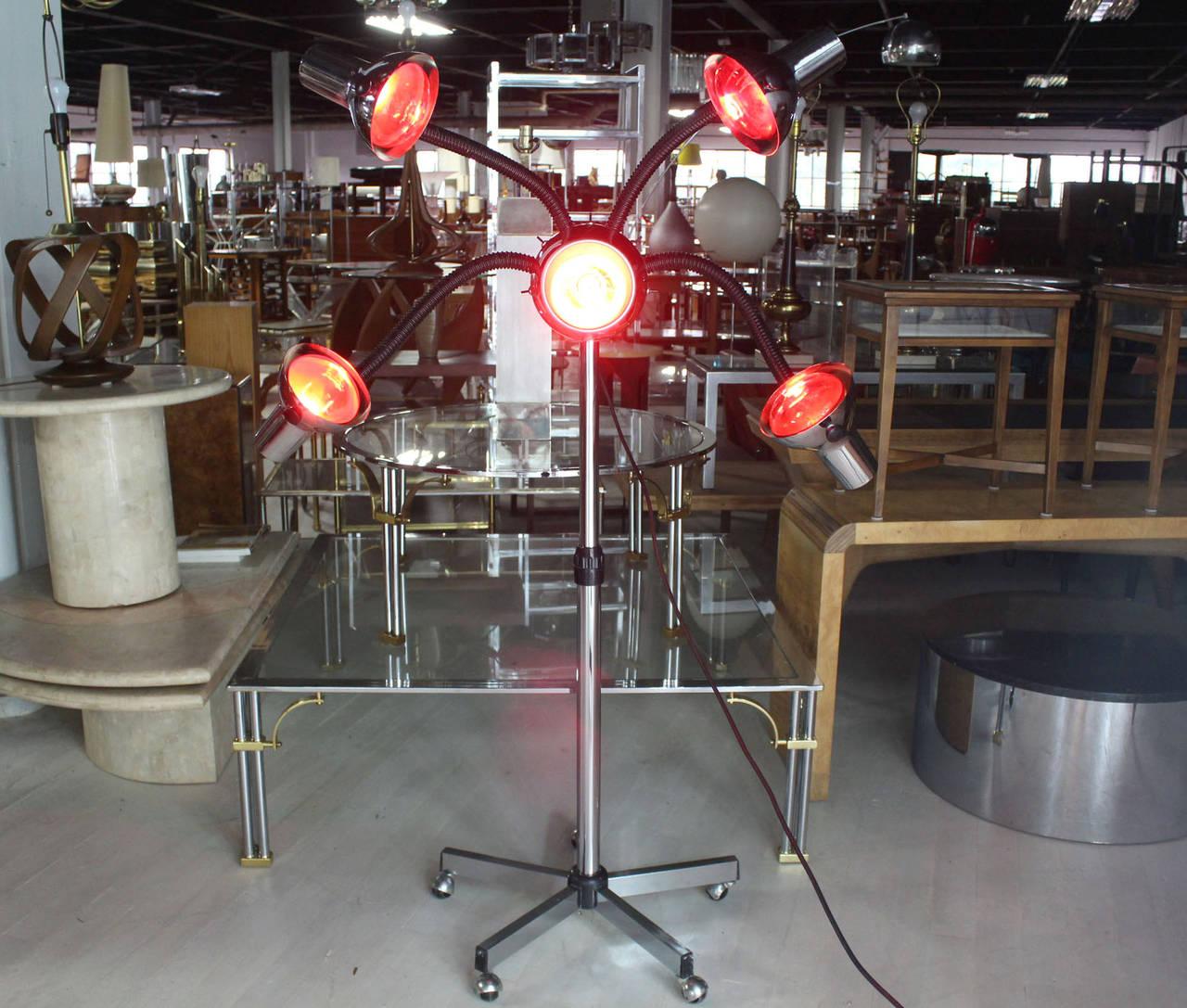 Very unusual Mid-Century Modern chrome base four flexible arms lamp. Currently showed with five red heat bulbs.