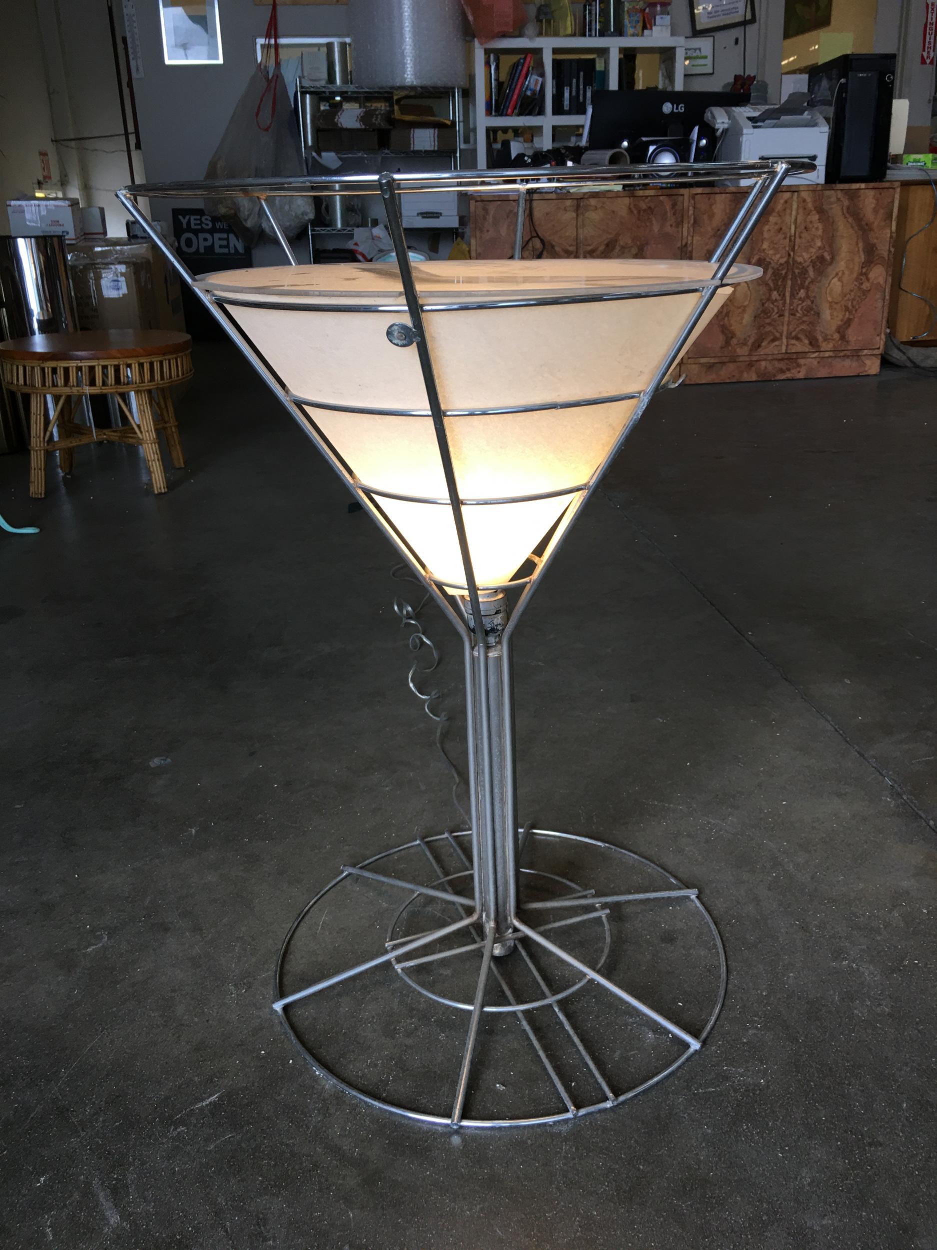 Vintage chrome wire art light up Martini lounge side table featuring a single bulb which illuminates a white surrounding paper shade and glass top. Perfect for the lounge in your home.

Available- 2 