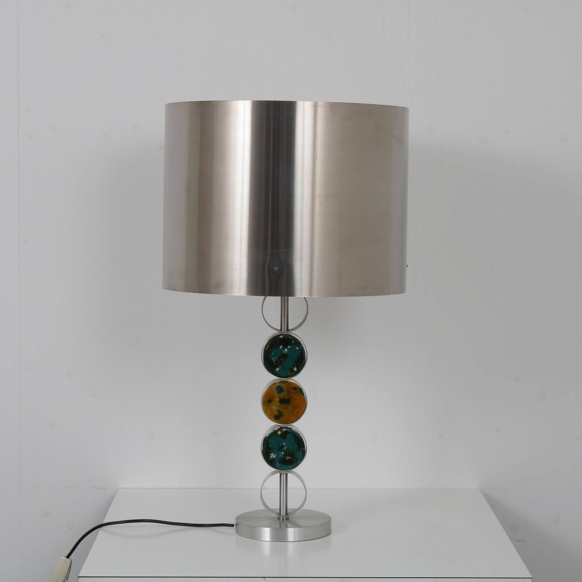 A wonderful table lamp designed by Nanny Still, manufactured by Raak around 1970.

The lamp is really nicely made of rounded shapes in chrome plataed metal. The round foot holds a cylinder arm and a cylinder shaped hood. The arm is decorated with