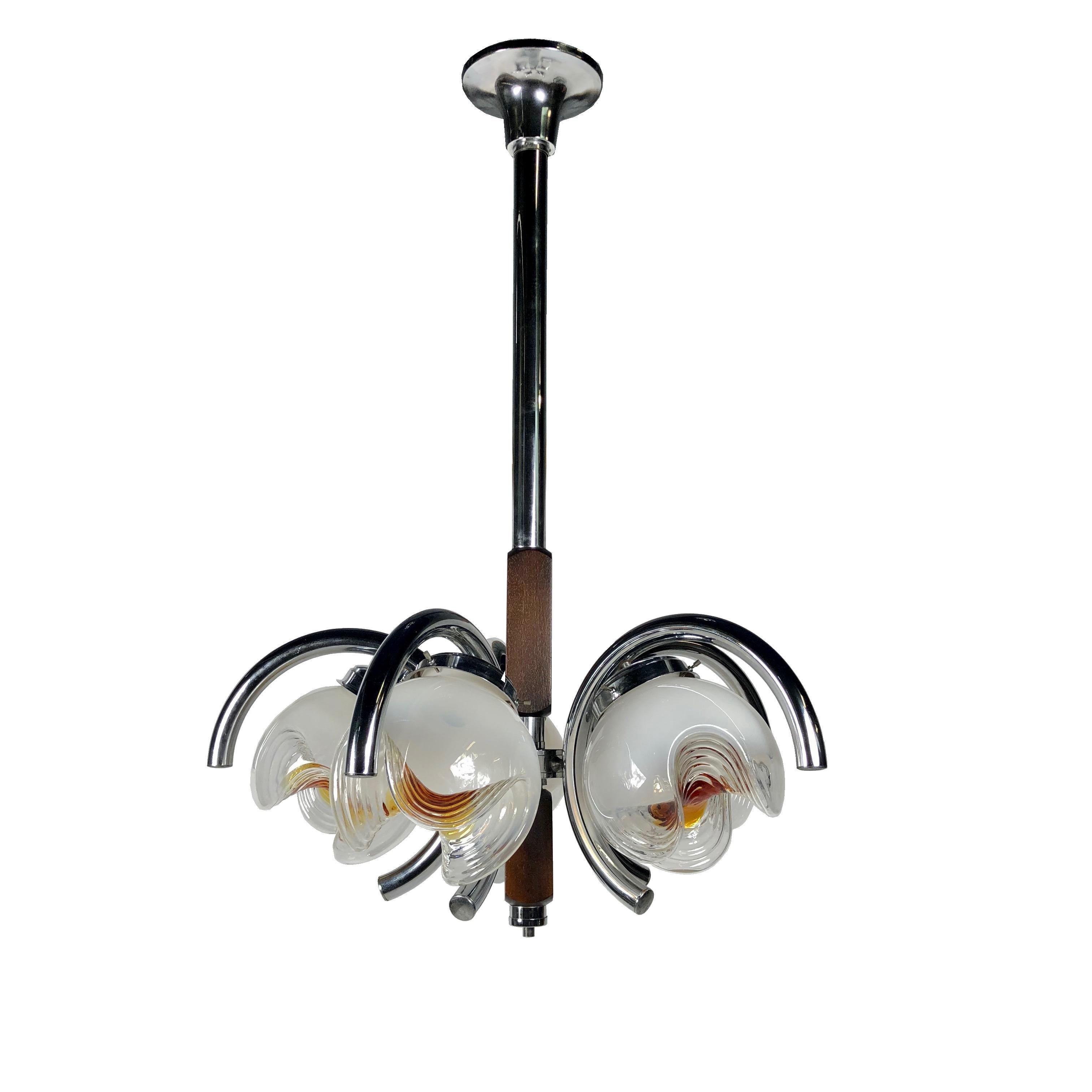 Chandelier pendant by Italian designer Mazzega, featuring his signature white to amber artistic handblown glass globes. Five Murano glass balls surrounded by curved chrome tubes and connected by on a long chrome pole covered with wood. 
Pretty soft