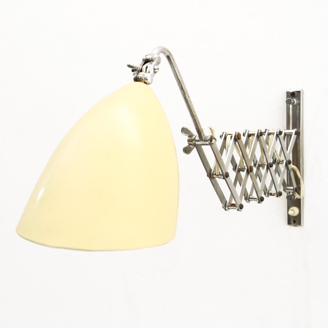 Italian-made wall lamp produced in the 1950s.
Wall fixing base and pantograph stem, in chromed brass.
Diffuser in white cream painted metal.
Extendable stem, articulated and directional diffuser.
Good general condition, some signs due to normal