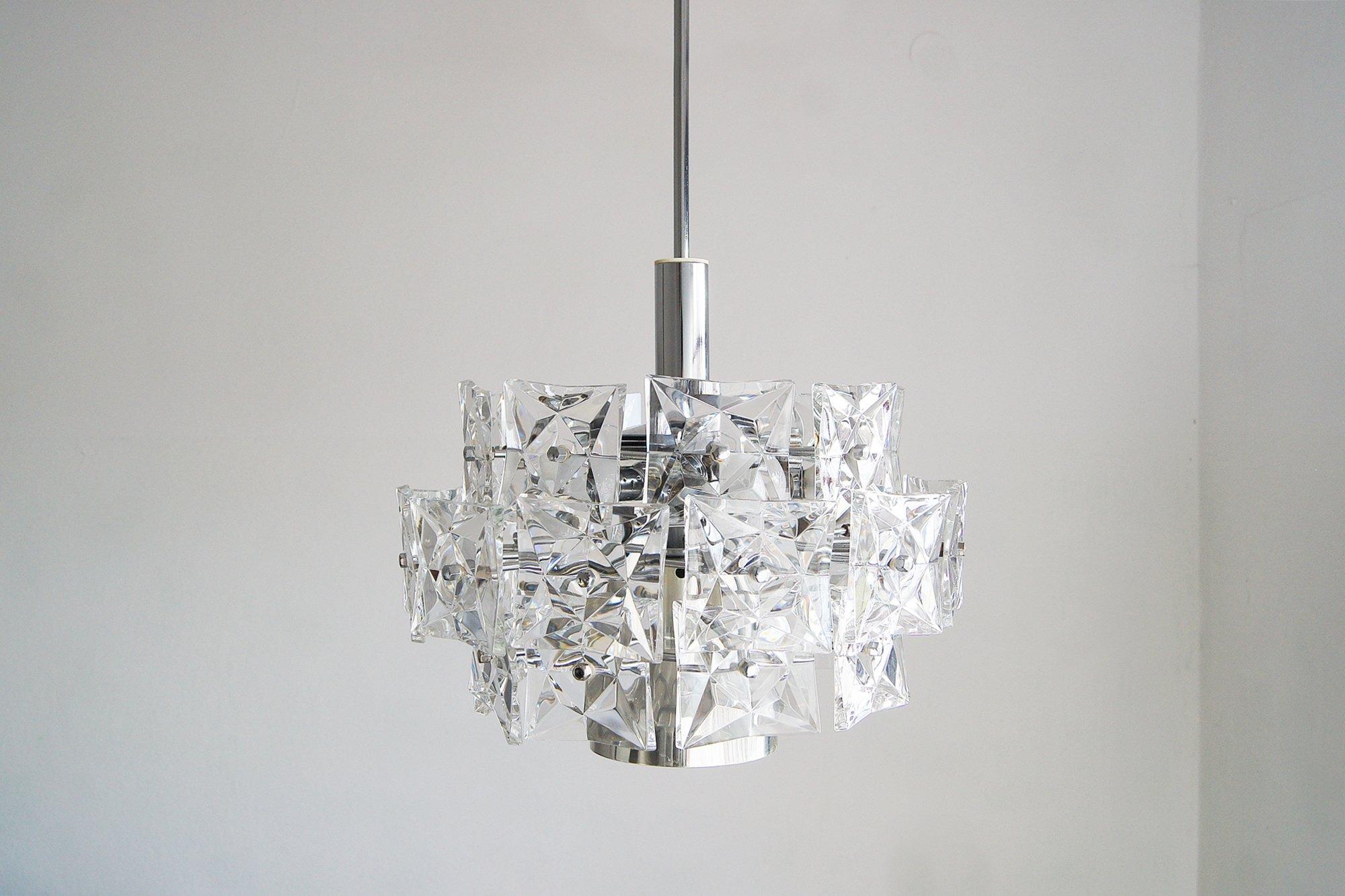 Un lustre spectaculaire à trois niveaux de la célèbre société Kinkeldey, icône du design d'éclairage allemand de la seconde moitié du XXe siècle. La structure, basée sur un cadre en chrome massif, est ornée de trente cristaux à facettes, taillés