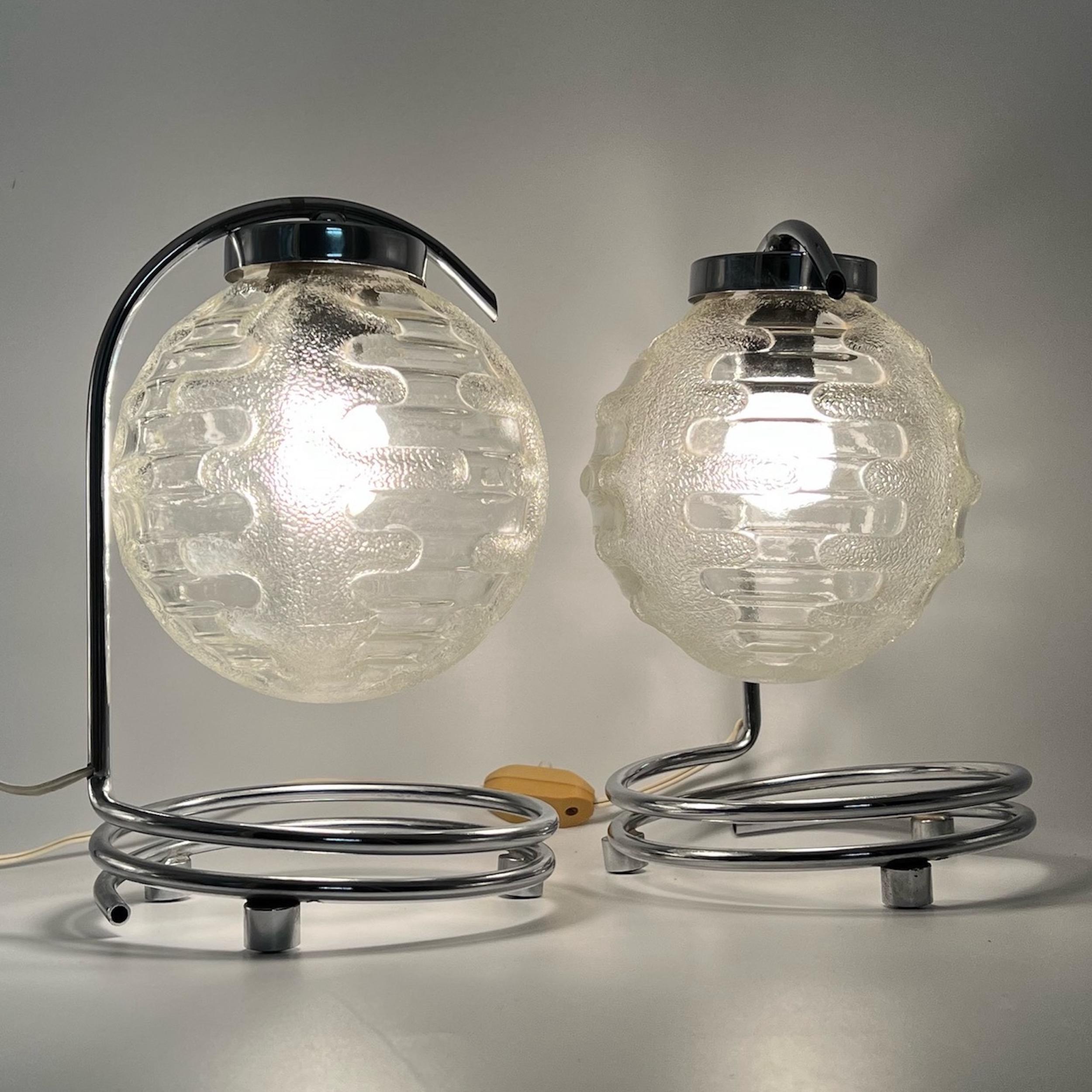 Beautiful pair of 70s desk or bedside lamps by Richard Essig.

The base is masterfully conceived with chromed metal spyrals, and the lamp shade is made of thick, crafted glass, for a gorgeous visual impact.

Excellent vintage conditions, perfectly