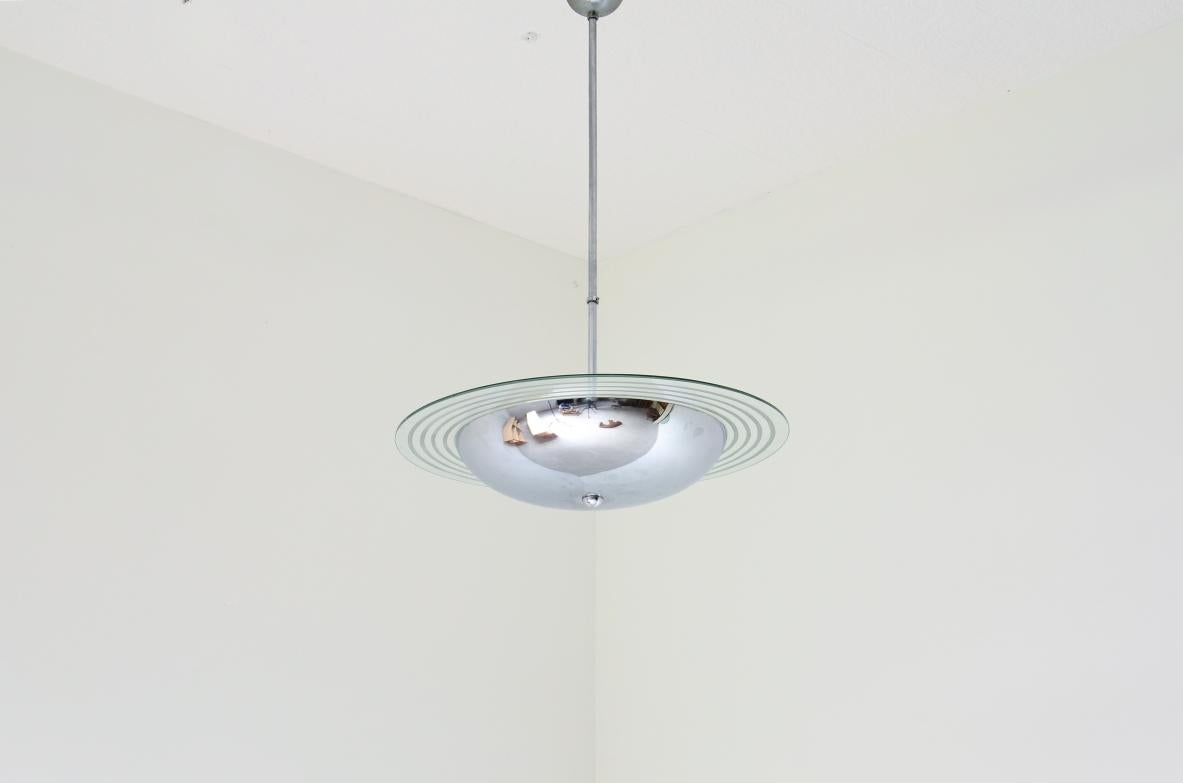 COD-z300
Chromed metal chandelier with cut and engraved crystal disc.

Italian manufacture ca. 1960.

h 100 diam 53 cm