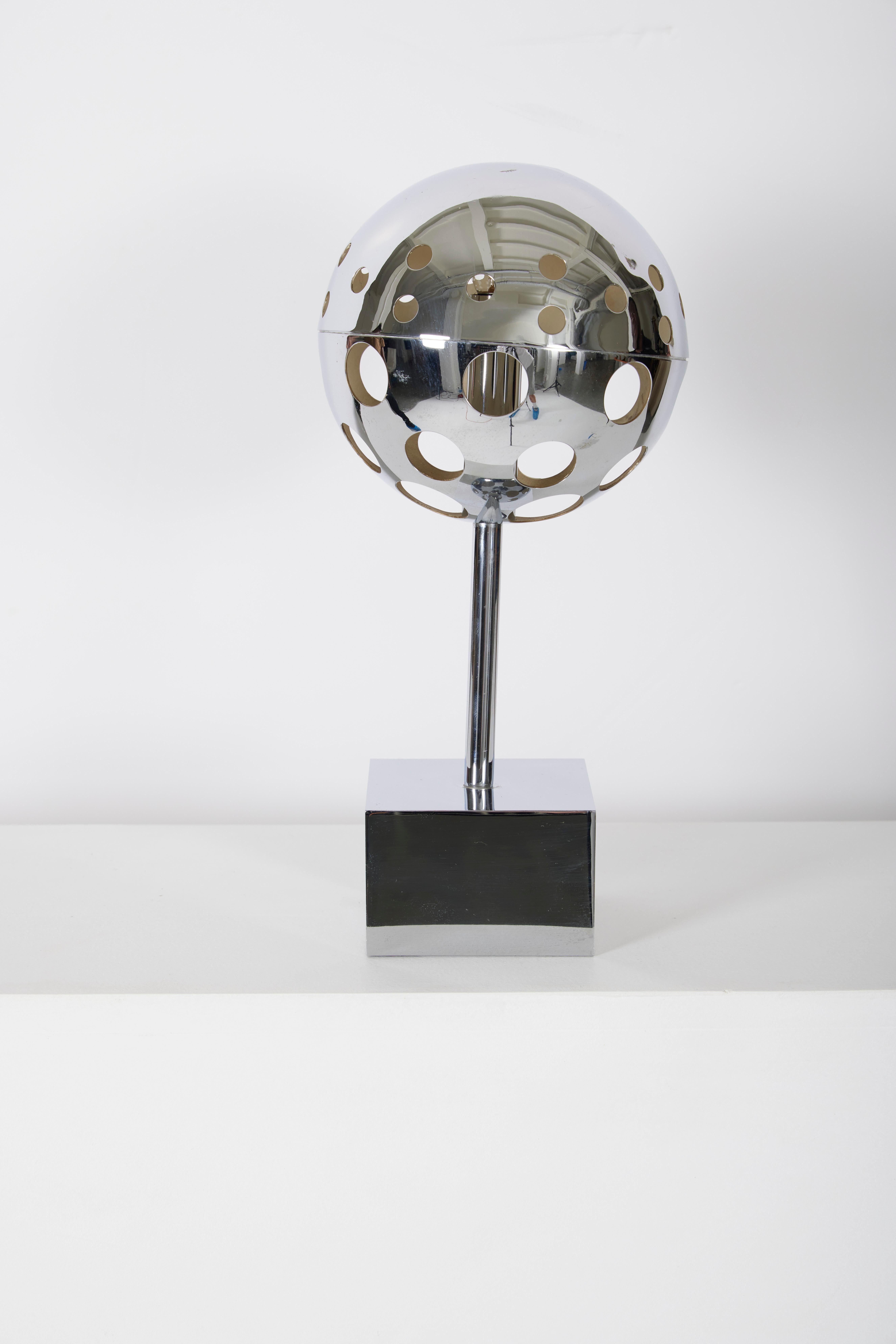 Lampe 10367 de Sabin Charoy, éditée par Verre Lumière, années 1970. Lampe de table en métal chromé, avec une sphère ajourée sur une base cubique. Fonctionnel.
LP1107