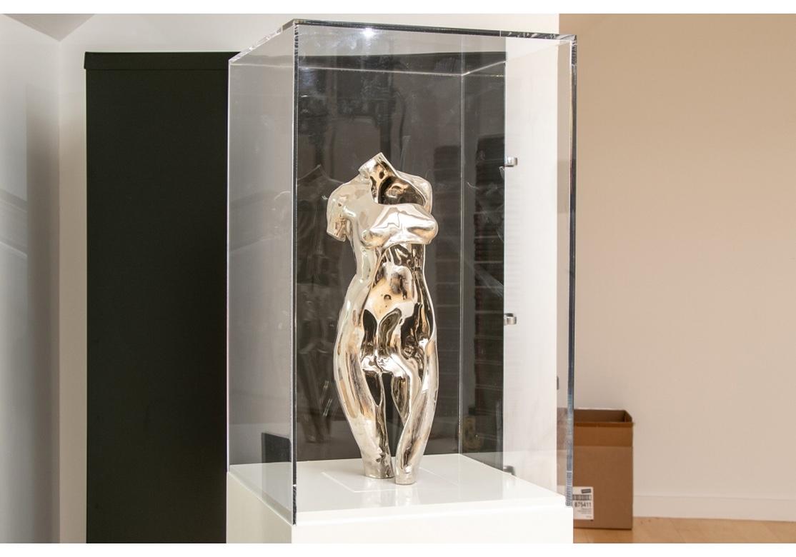 Very fine chromed metal sculpture of nude female torso in the manner and style of Ernest Trova having a chrome finish, unsigned, mounted on marble plinth, housed in custom display cabinet with clear acrylic top. And white wood rectangular base. The
