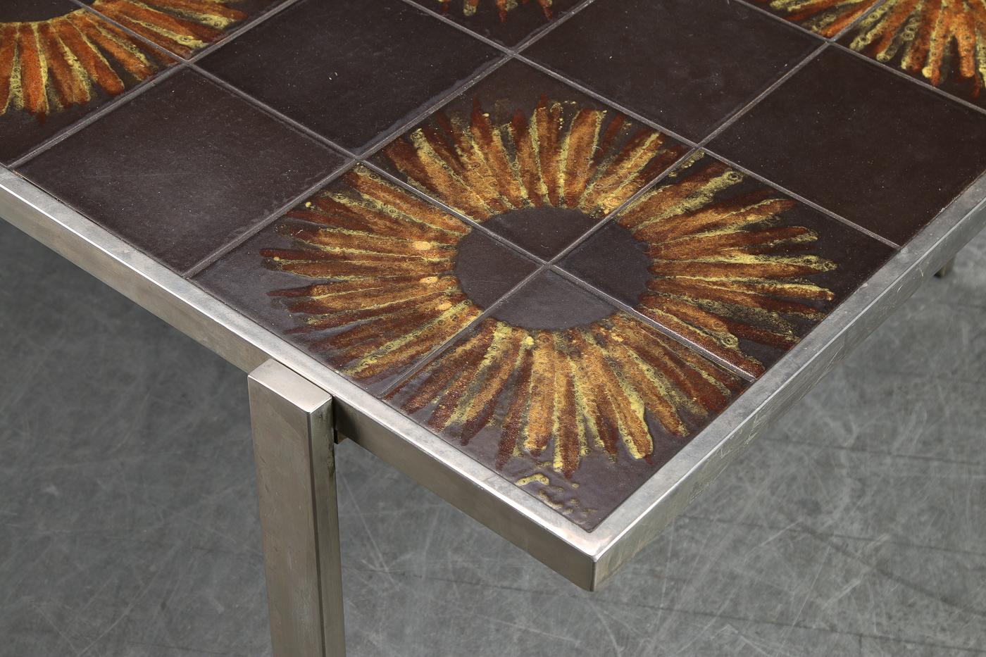 Danish modern coffee table in chromed steel with tiled top in sunflower motif. Signed Trans. 
 