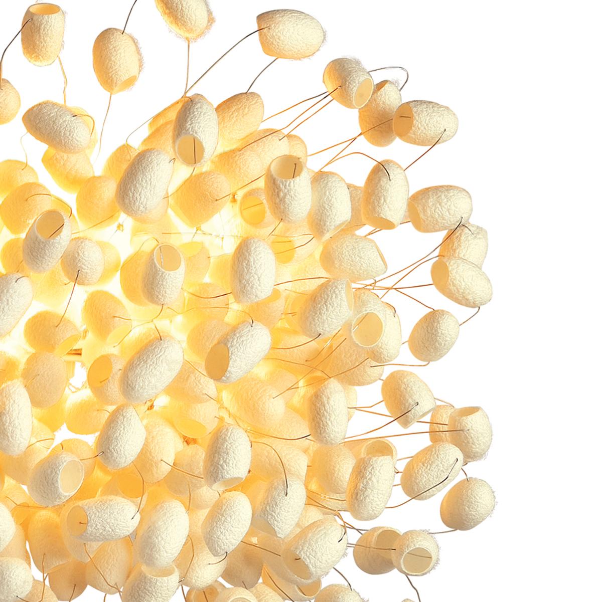Chrysalis Wall, una versione di lampada da parete della serie classica iniziata con la lampada da terra Chrysalis Sky, è formata da una configurazione casuale di bozzoli di seta selezionati a mano. 

Ogni bozzolo è circondato da un'aura di finissima