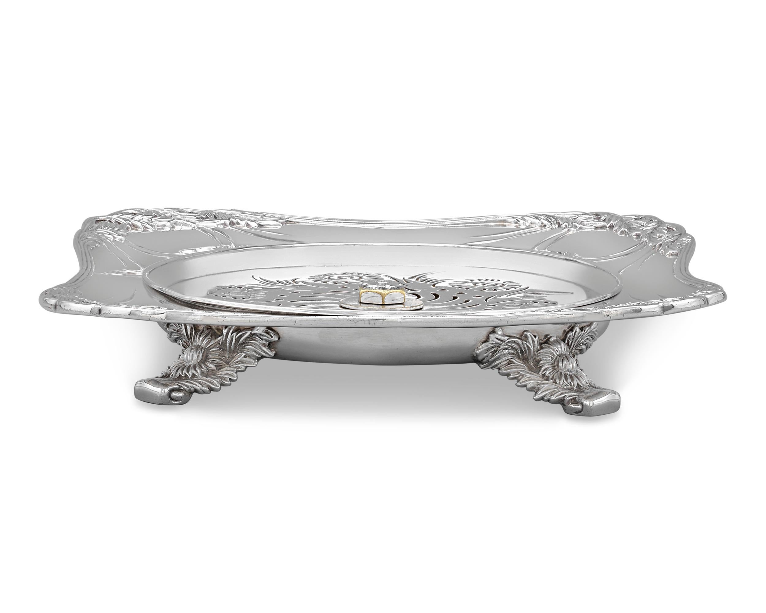 This charming sterling silver caviar server was crafted by the celebrated Tiffany & Co. in the firm's highly popular Chrysanthemum pattern. The dish is ingeniously designed to keep caviar at the perfect temperature, with a removable pierced tray at
