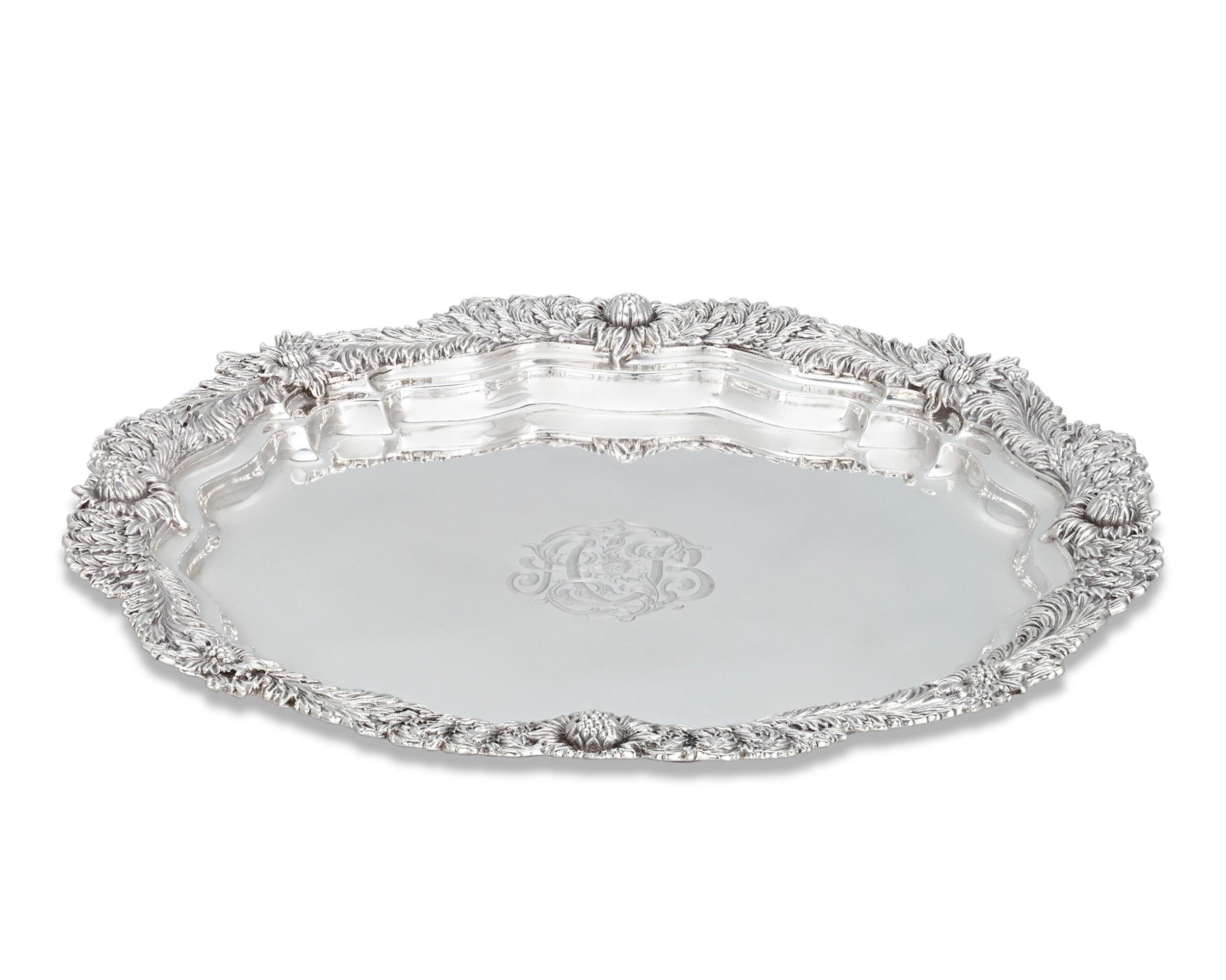 This impressive sterling silver serving tray was crafted by Tiffany & Co. Executed in the firm's famed Chrysanthemum pattern, the tray's decorative border is beautifully adorned with chrysanthemum blooms that follow the graceful curves of the