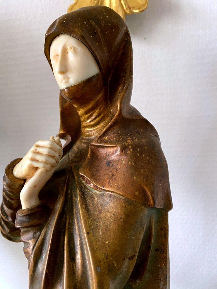 Magnificent bronze chryselephantine, green and gold patina, on a green onyx marble base from Pakistan, with white and brown veins, the face and hands are in ivory and it represents the Virgin of Calvary called 