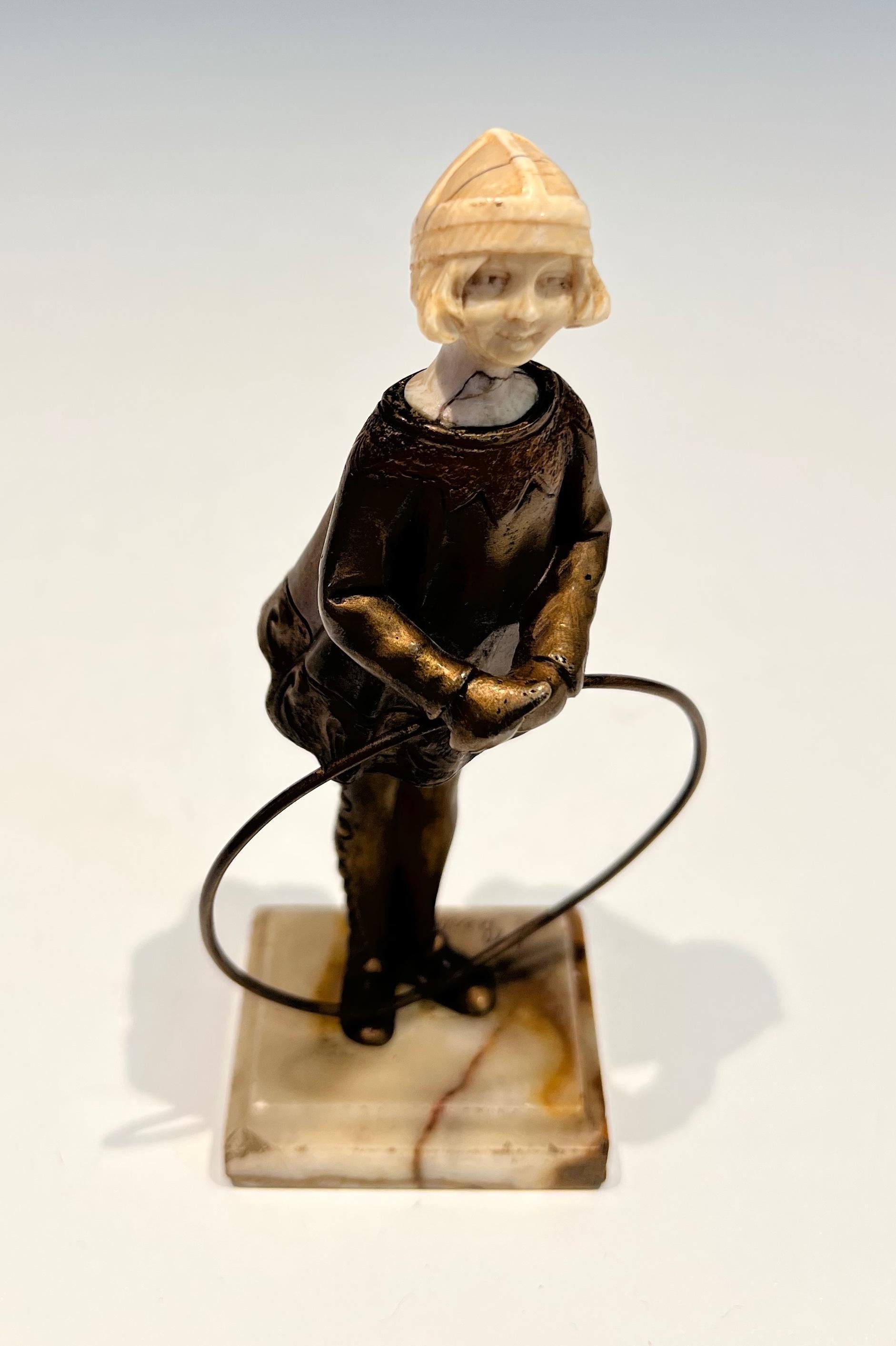 This charming chryselephantine represents a young girl with a hoop. This sculpture is made of a bronze body and hoop and ivory head (Head restored). This is a French work signed Bertrand on its Onyx base. Circa 1900