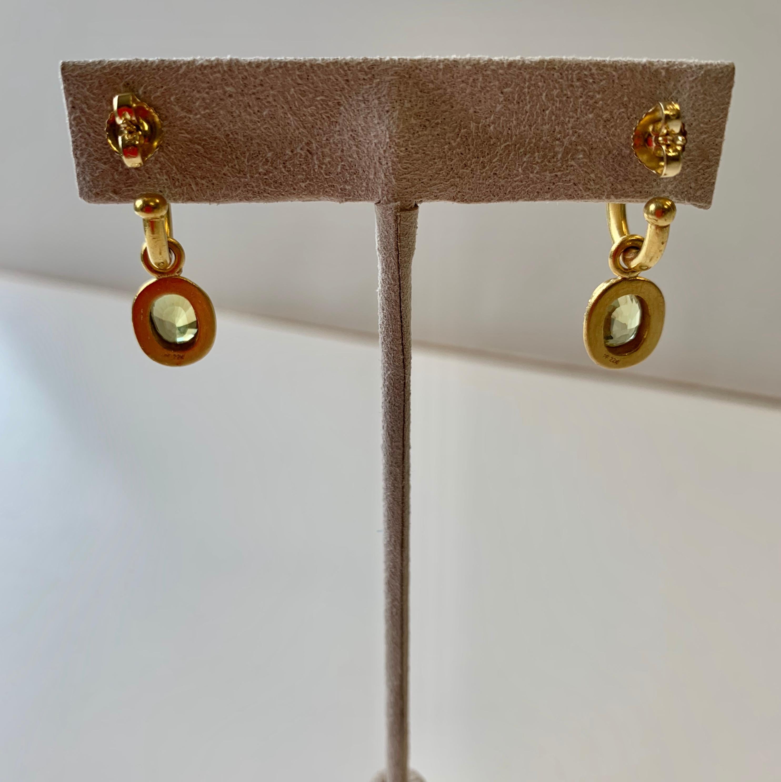 Entirely handmade 22 karat gold hoop earrings with incredibly sparkly, fine oval chrysoberyl drops. Chrysoberyl is a rare gem that is both brilliant in color and extremely durable. The Chrysoberyl gems found here weight 3.63 carats. They are set