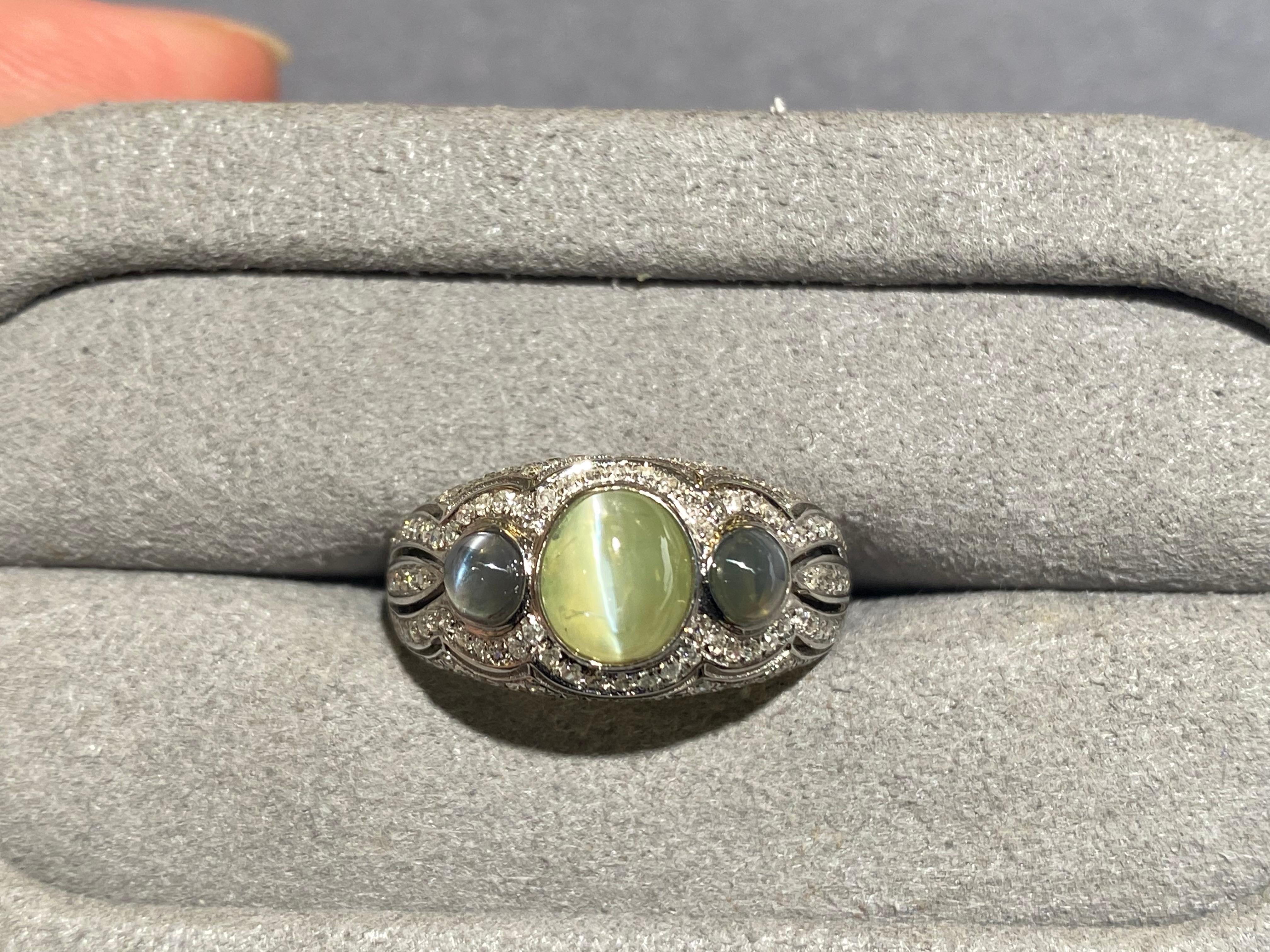 A 1.9 ct Chrysoberyl cat's eye 3-stones ring with Alexandrite cat's eye and diamond. The chrysoberyl cabochon is set in the middle of 2 alexandrite. The 3 stones are surrounded by micro diamond pave. The chrysoberyl has clear and sharp chatoyancy