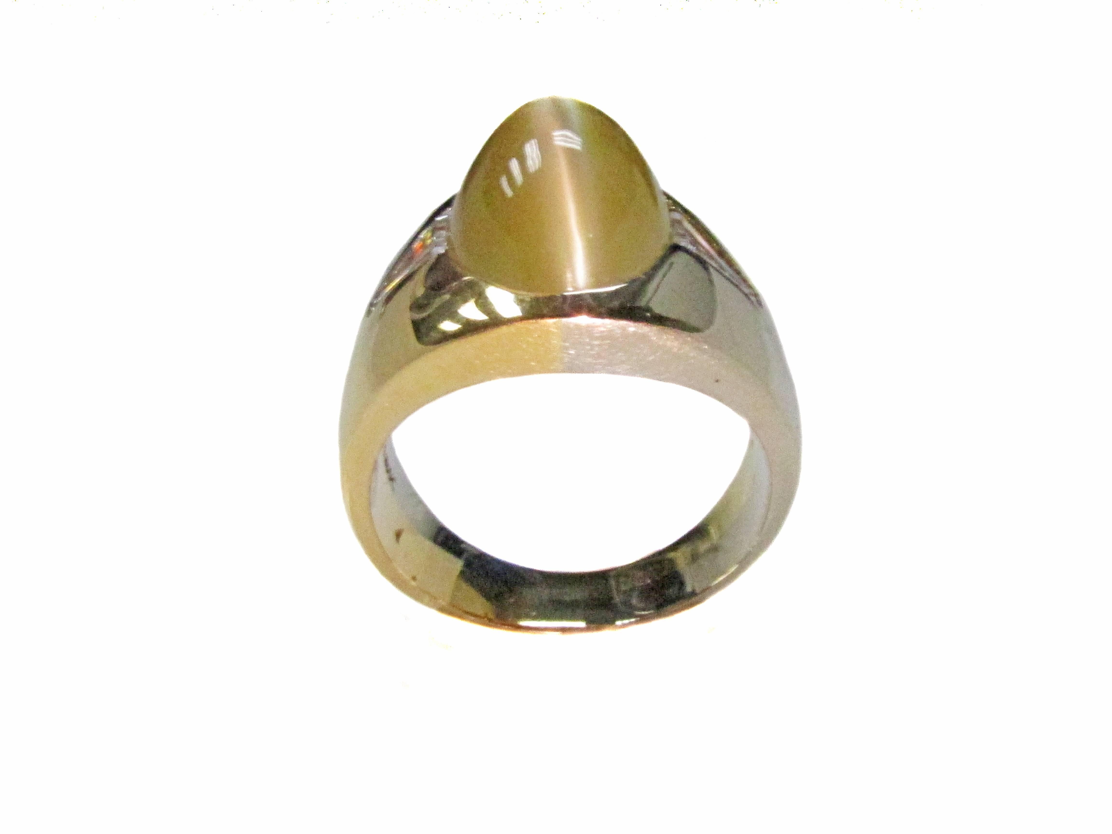 Stunning 2 color 18 karat gold gypsy ring with a center Chrysoberyl Cat's-Eye weighing approximately 8 carats. This gemstone displays an incredibly sharp eye moving across the top of the cabochon with every movement of the hand. The Cat's-Eye