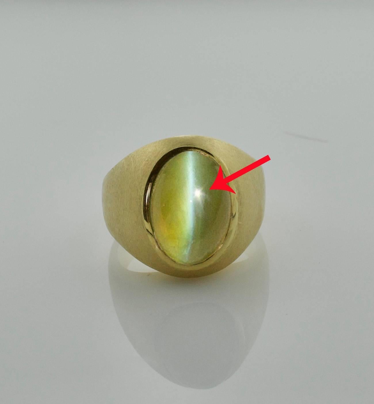 Chrysoberyl Catseye in 18k Yellow Gold Substantial Ring 
Weighing 14.71 Translucent Honey Colored with a Well Defined Eye
The Pictures are of The Actual Eye.  The Red Arrow points to  a Reflection of The Sun.  It' s NOT in The Stone or an