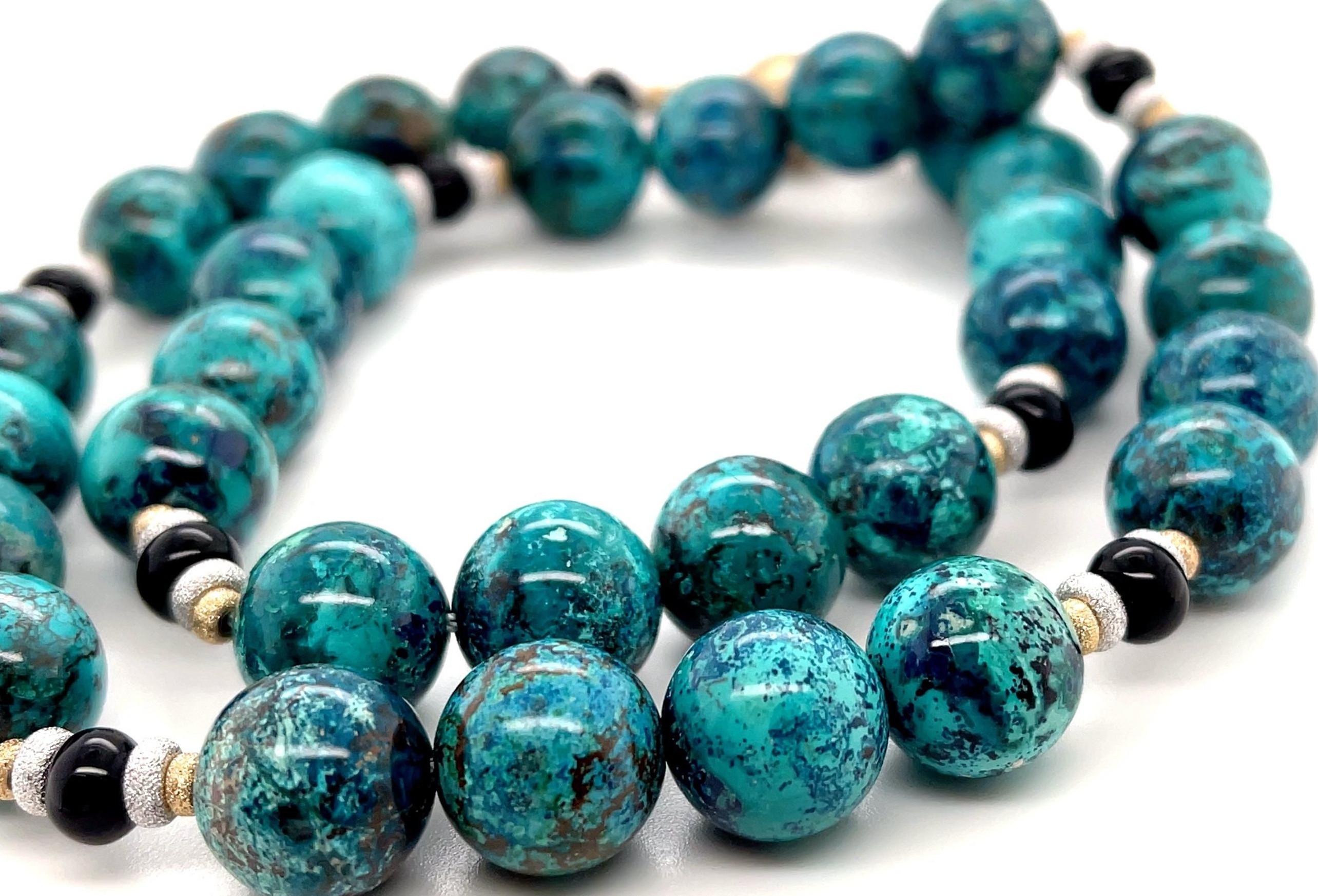 Diese atemberaubende Halskette besteht aus wunderschön gefärbten Chrysokoll-Quarzperlen, die mit schwarzem Onyx und 18-karätigen Goldspacern kombiniert sind. Die 12 mm großen, runden Chrysokoll-Perlen mit ihren auffälligen Mustern in sattem Türkis-,