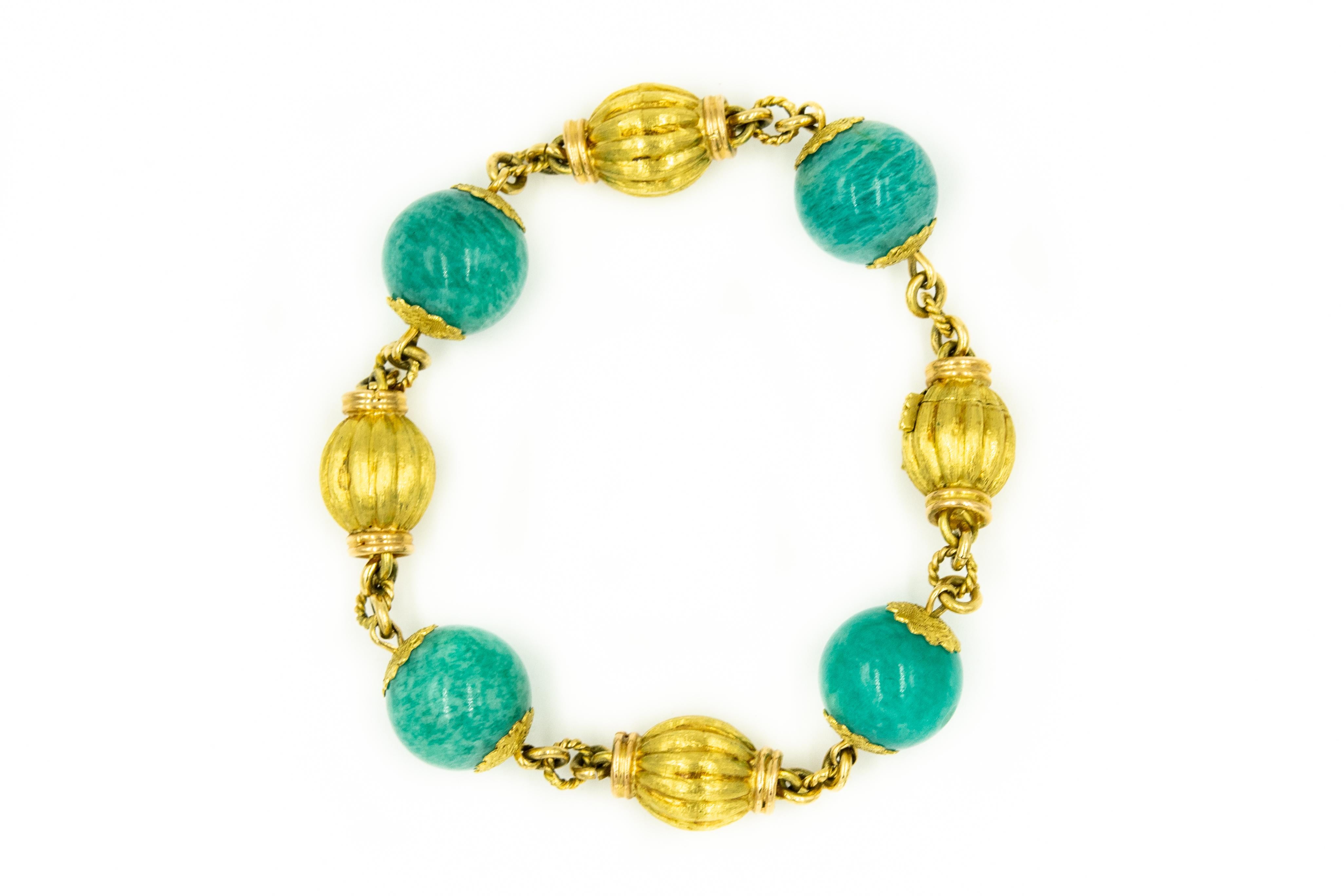 Superbe bracelet italien en or jaune 18k contenant quatre perles de chrysocolle (environ 12 mm) serties parmi quatre perles cannelées ou nervurées en or jaune 18k.  La dernière perle est en fait le fermoir à bouton-poussoir qui possède une sécurité