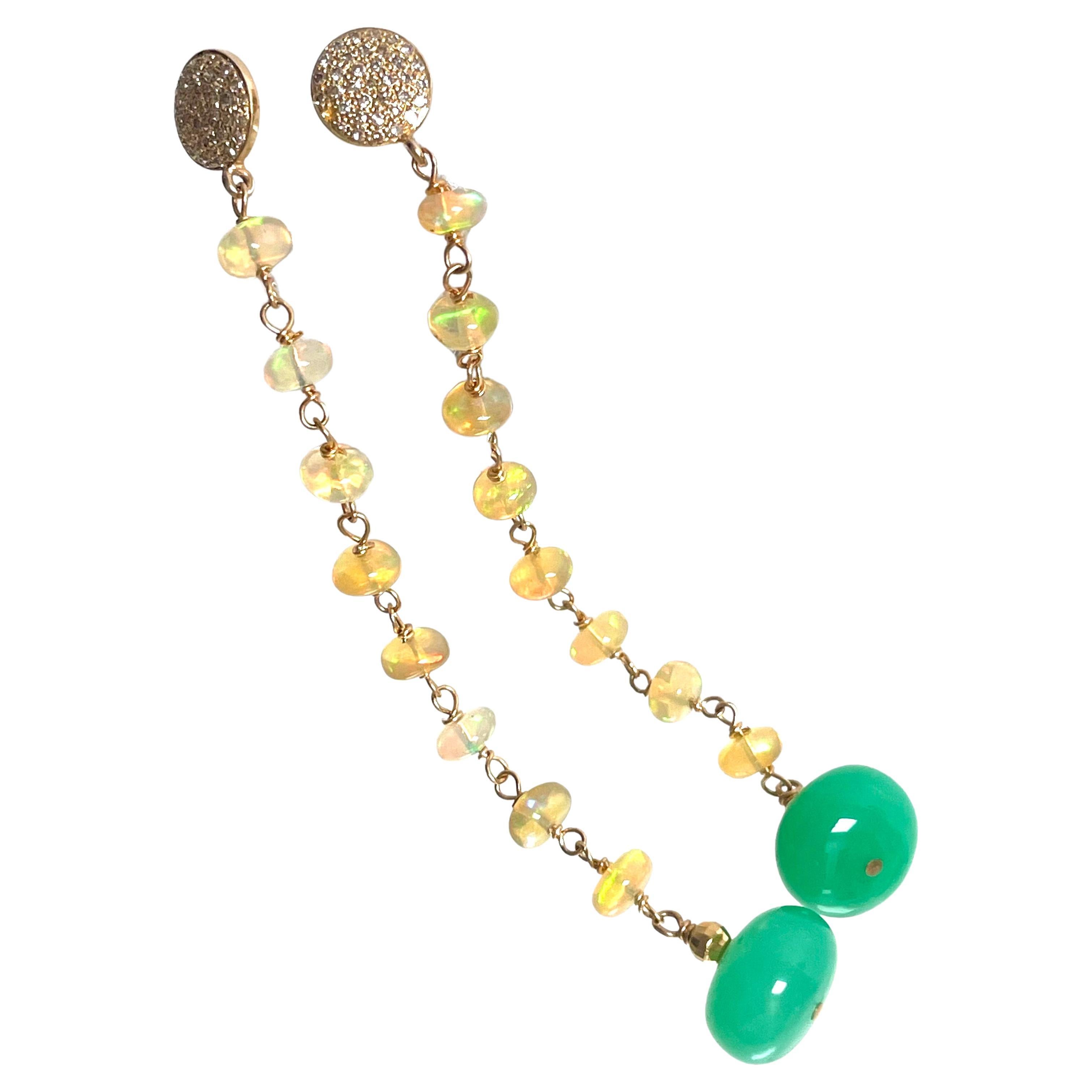 Description
A dramatic line of exquisite Ethiopian Opals shimmer with yellow, green and red beams of light, punctuated at the bottom with vibrant green Chrysoprase drops and faceted gold beads. Each Opal is meticulously hand wire wrapped with