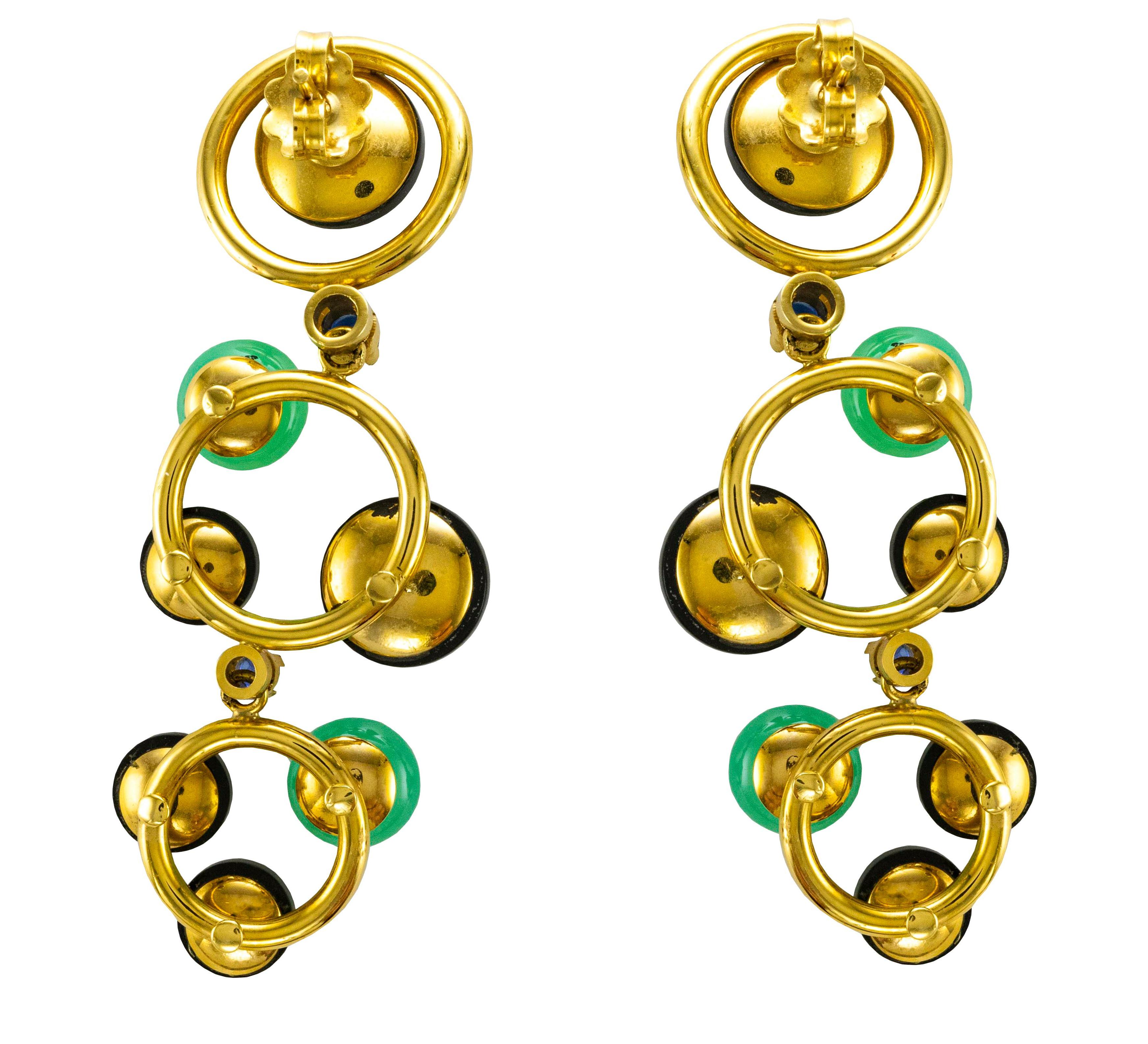 18 Karat yellow gold articulate drop earrings made up of three gold circles, Onyx discs and cabochon cut Chrysoprase.
Embellished with Diamonds ( ct 0.15 ), Rubies ( ct 0.42 ) and two Sapphires.
This earrings has a remarkable Seventies inspiration
