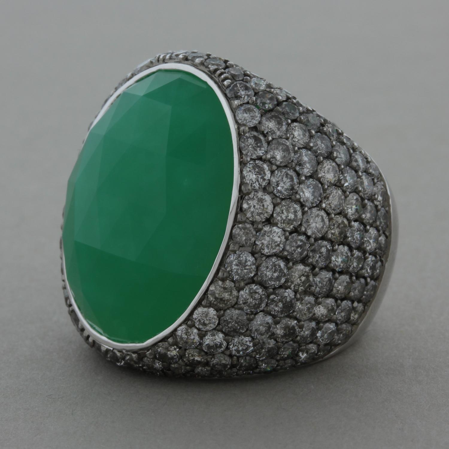 This exquisite cocktail ring features an faceted cabochon apple green chrysoprase. It is surrounded by 6.42 carats of pave set diamonds in an 18K white gold setting.

Ring Size 6.5 (Sizable)
