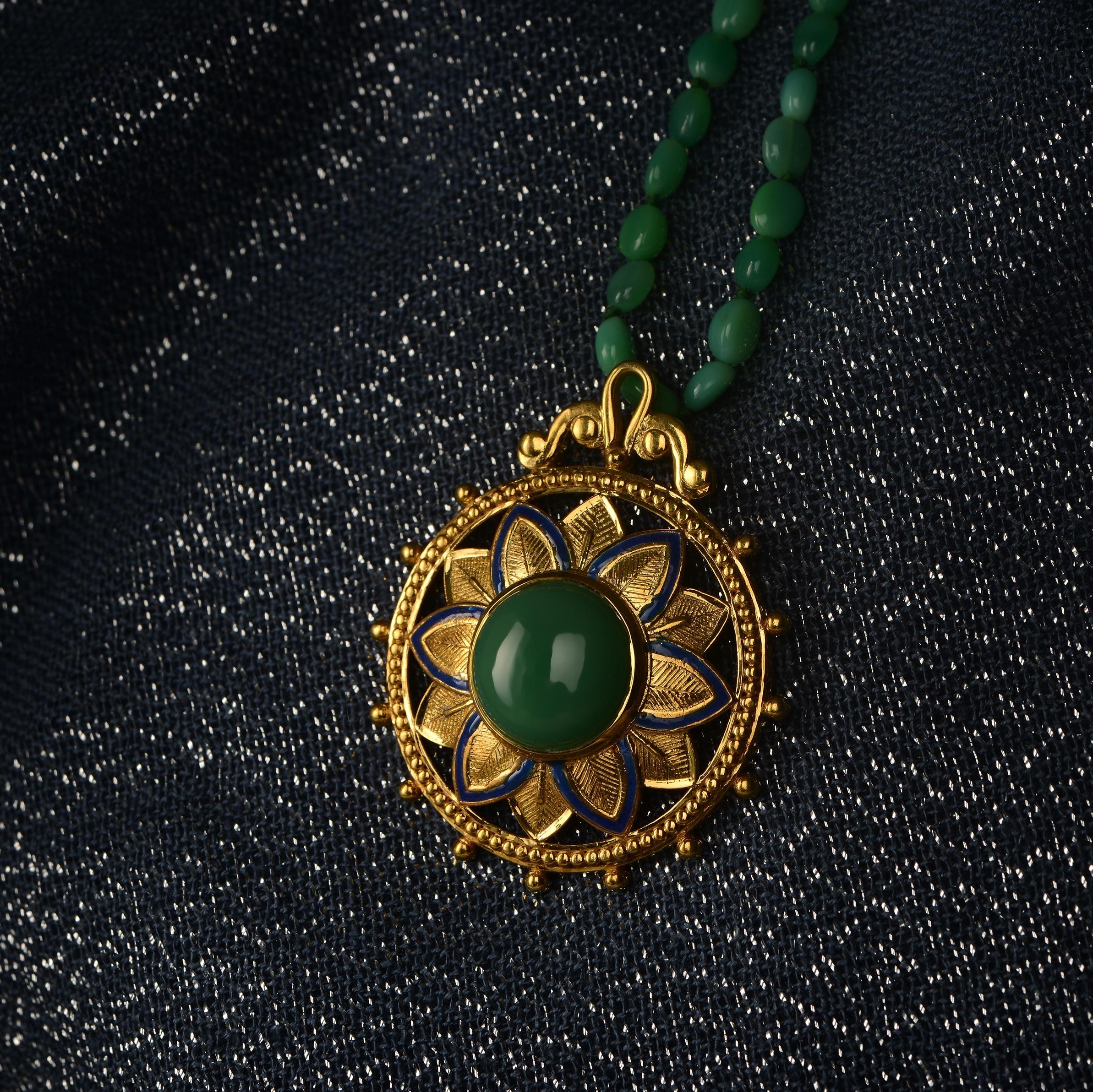 

This fabulous chrysoprase statement pendant has been handmade in our workshops. We have used the intricate techniques of embossed, jaali and hand engraving work in this pendant, and embedded it with chryosprase. For a finishing touch we have added