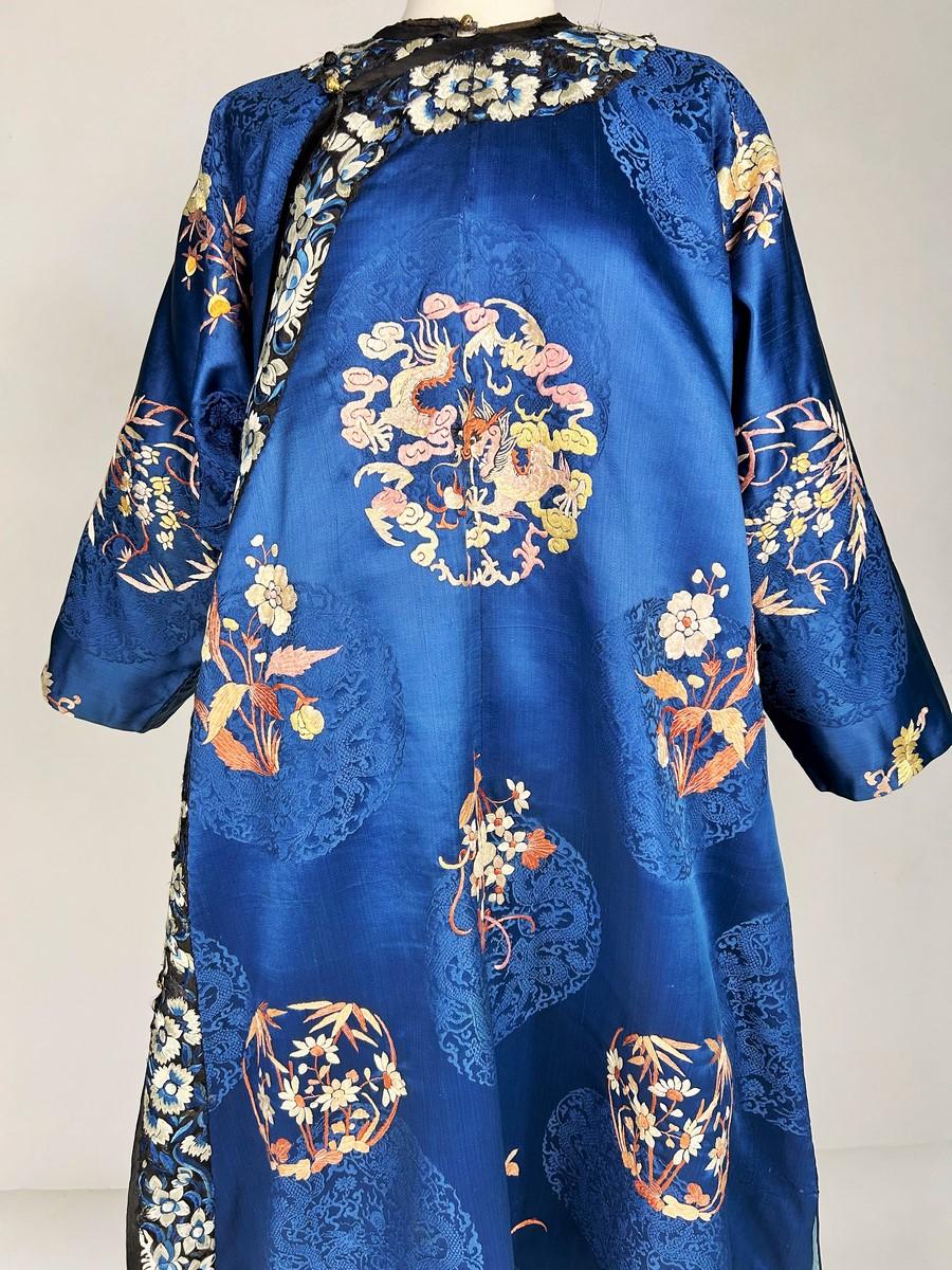 Circa 1880/1920
Il Tibet
Cappotto di un dignitario tibetano o Chuba tra il 1880 e il 1920. Sfondo in raso damascato cinese blu elettrico con grandi stemmi che rappresentano simboli taoisti. Ricamo policromo in seta floche con bouquet floreali e