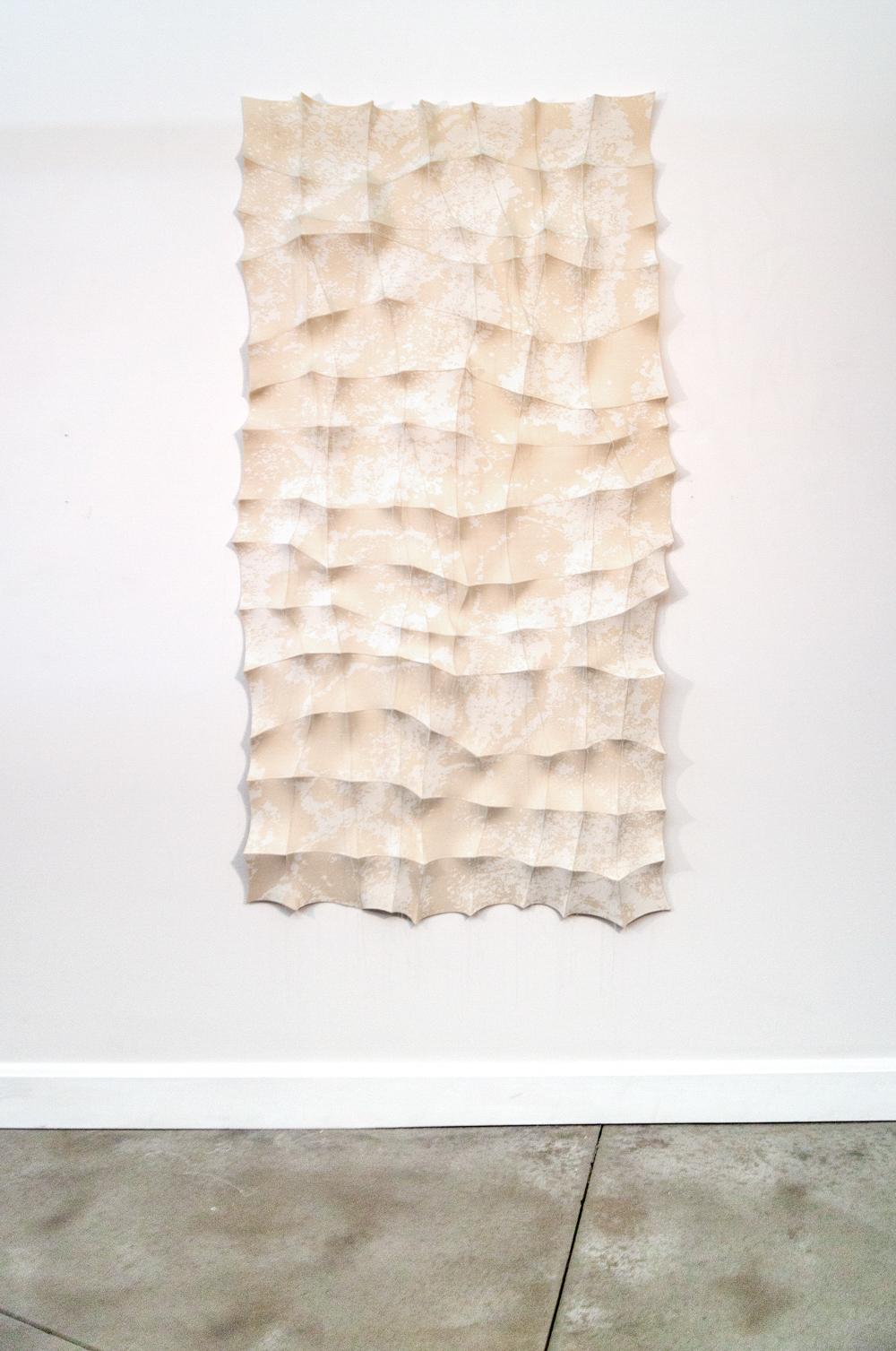Inspired by the ancient markings of imposing natural rock formations seen at an American National Park, Chung-Im Kim has created a new series of striking fabric wall tapestries. Kim painstakingly sews together small pieces of fabric that are pulled